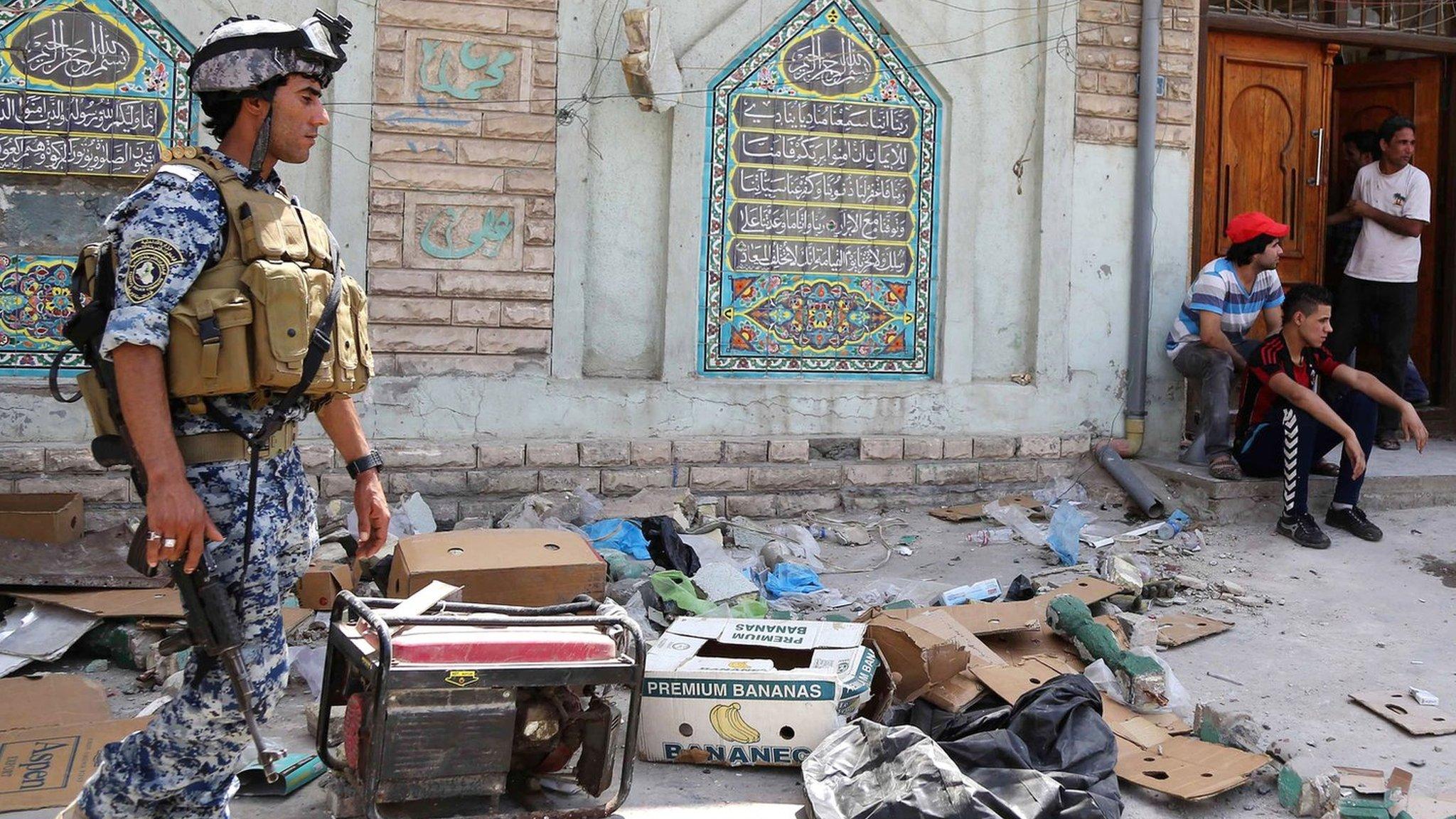 Iraqi security forces and civilians inspect the site of a suicide attack at a mosque in the Shorja market area in central Baghdad