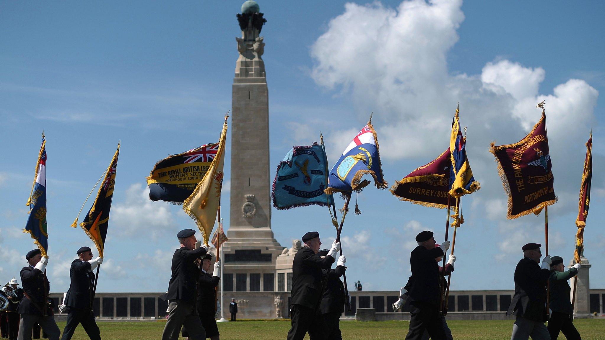 Veterans marching past memorial