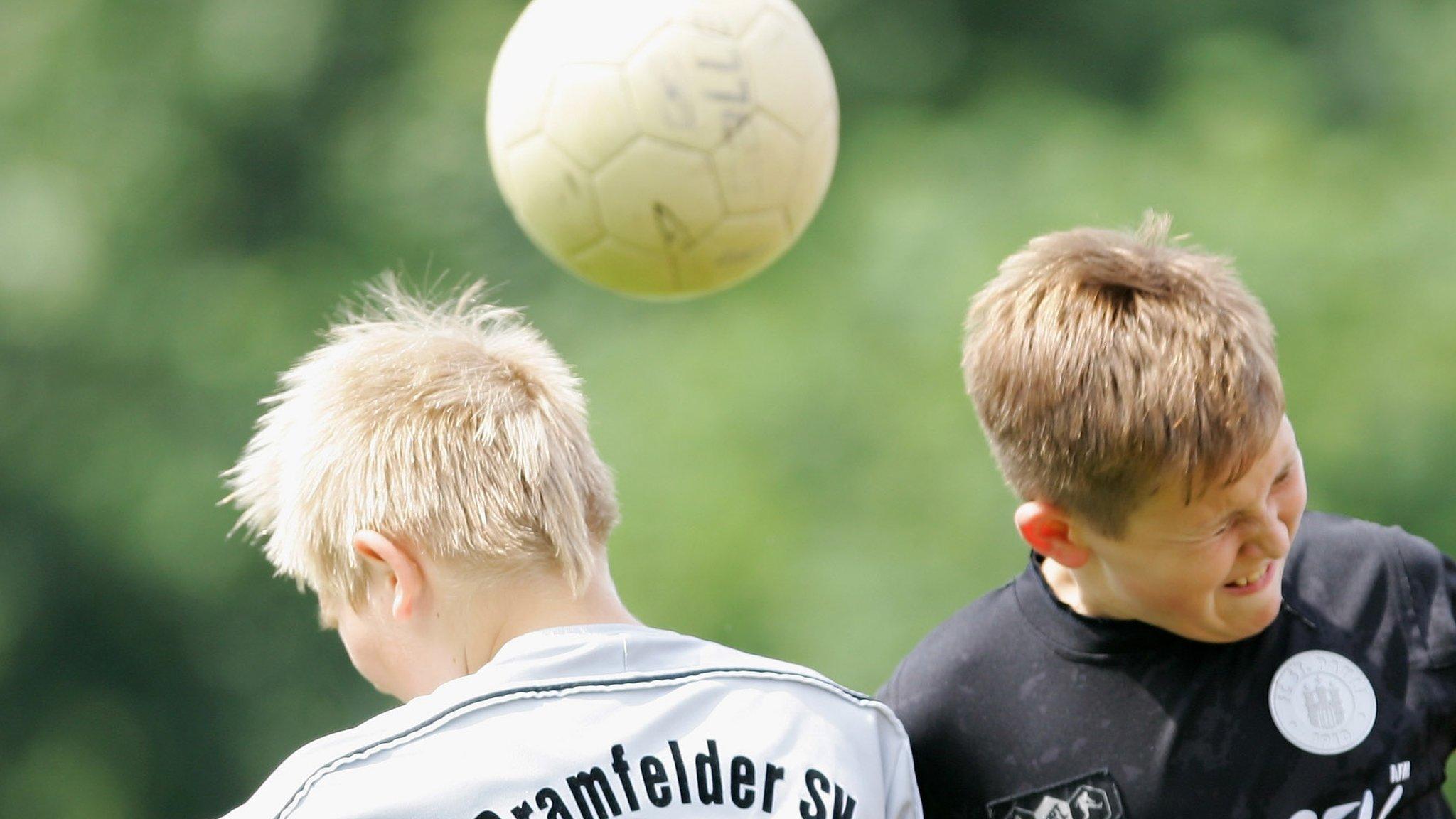 Young footballers attempt to win a header