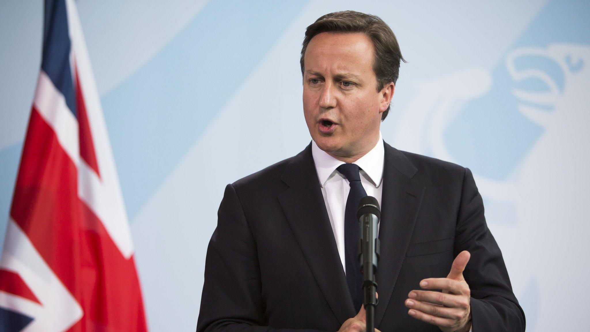 David Cameron giving a speech in 2012 with a Union Jack in the background