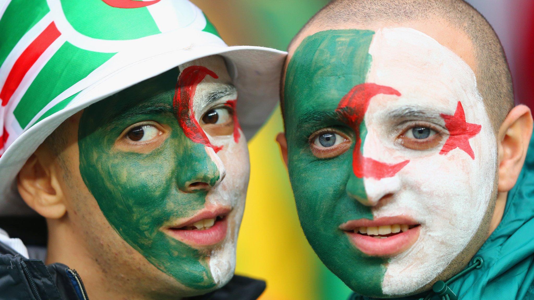 Two Algeria fans with their faces painted as the Algerian flag