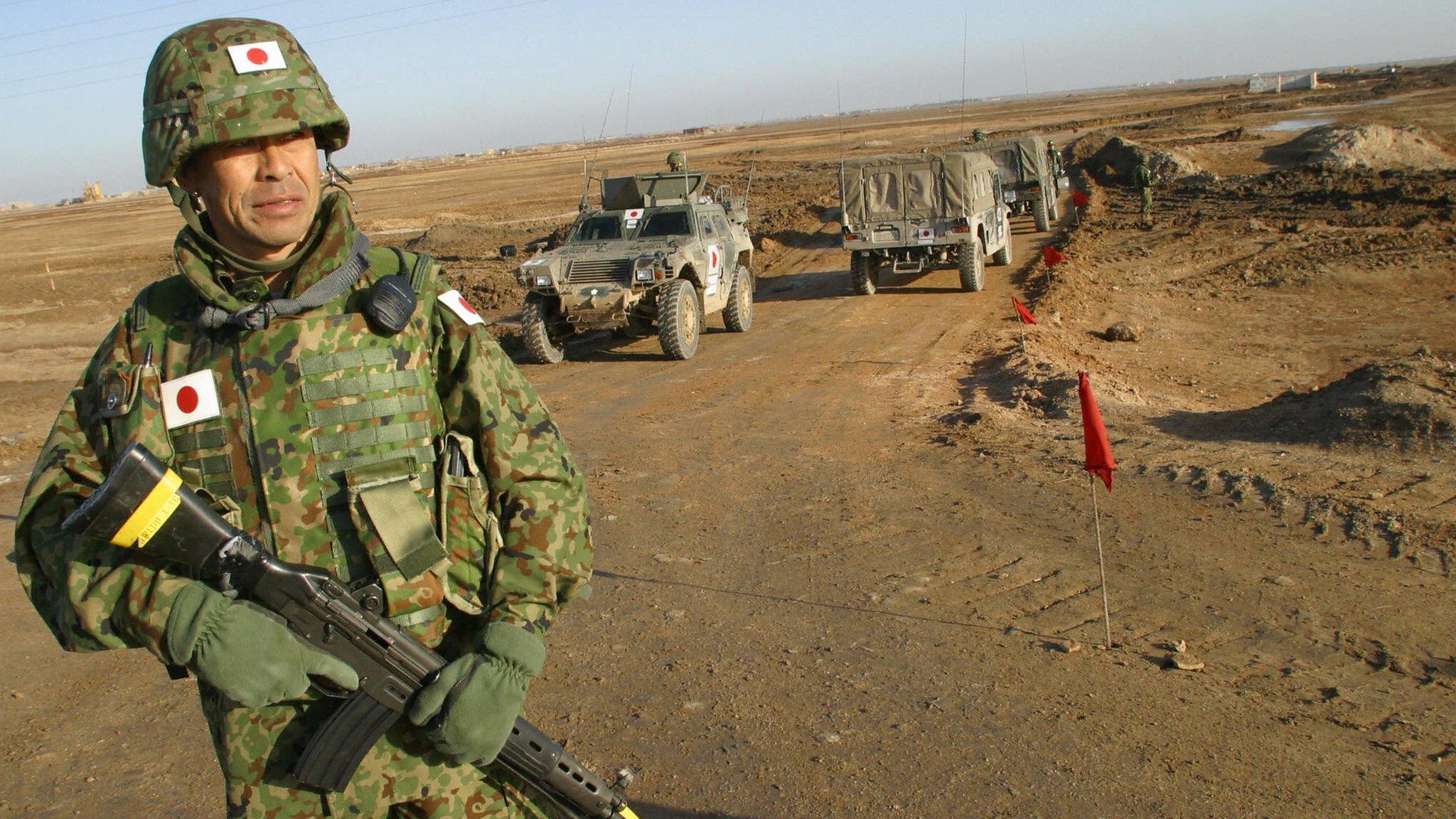 A Japanese soldier stands on guard during a visit by Japanese Self-Defence Force Commander Lt-Col Masahisa Sato to the area where a Japanese military base for troops in Iraq will be established in al-Muthanna province on 28 January 2004