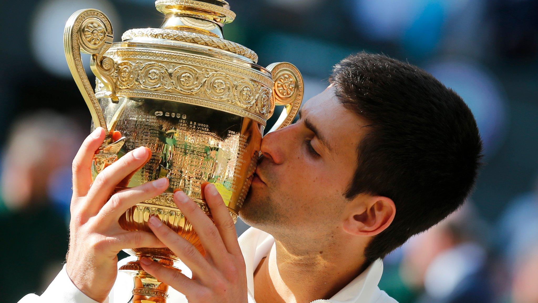 Djokovic kissing the Wimbledon trophy