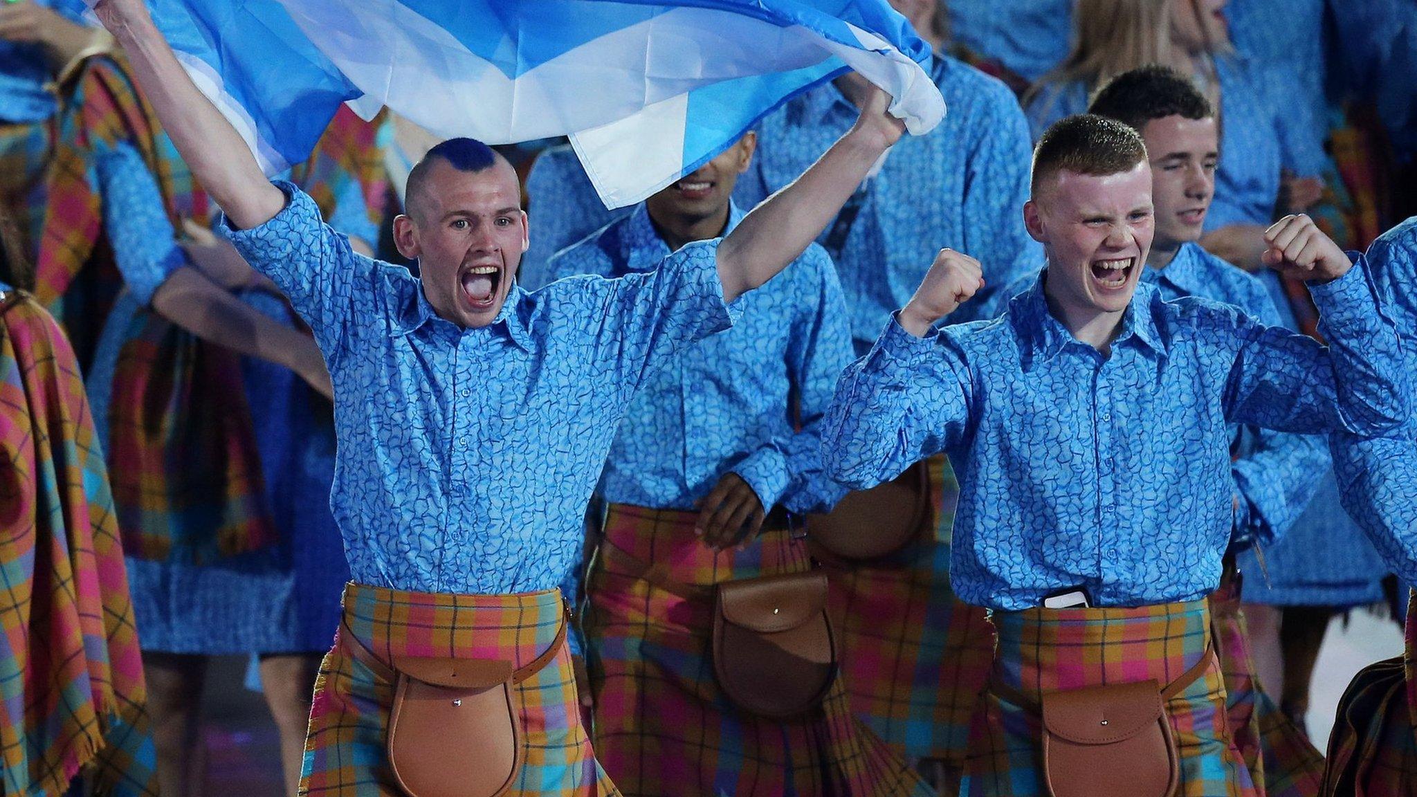 Tartan-clad performers holding the Saltire