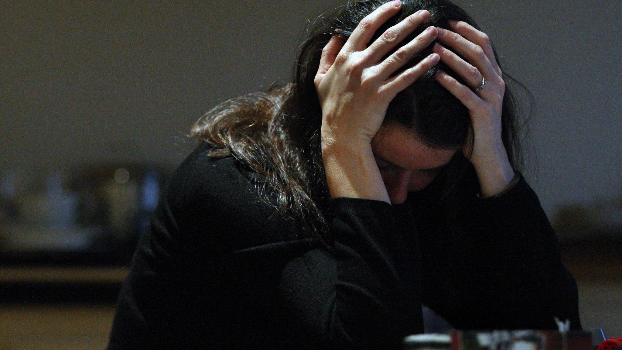 A woman holding her head in her hands