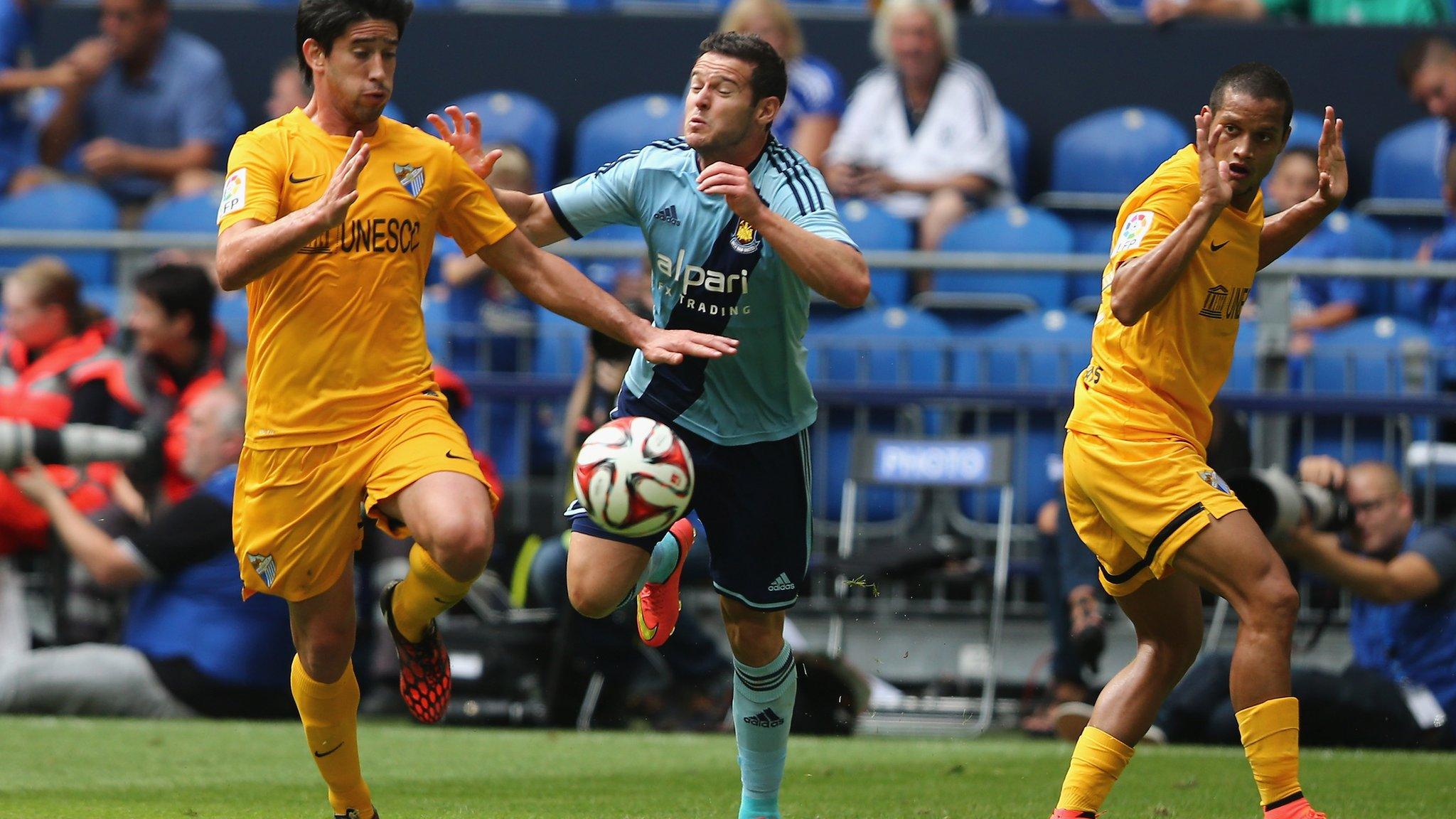 Mauro Zarate of West Ham challenged by two Malaga players