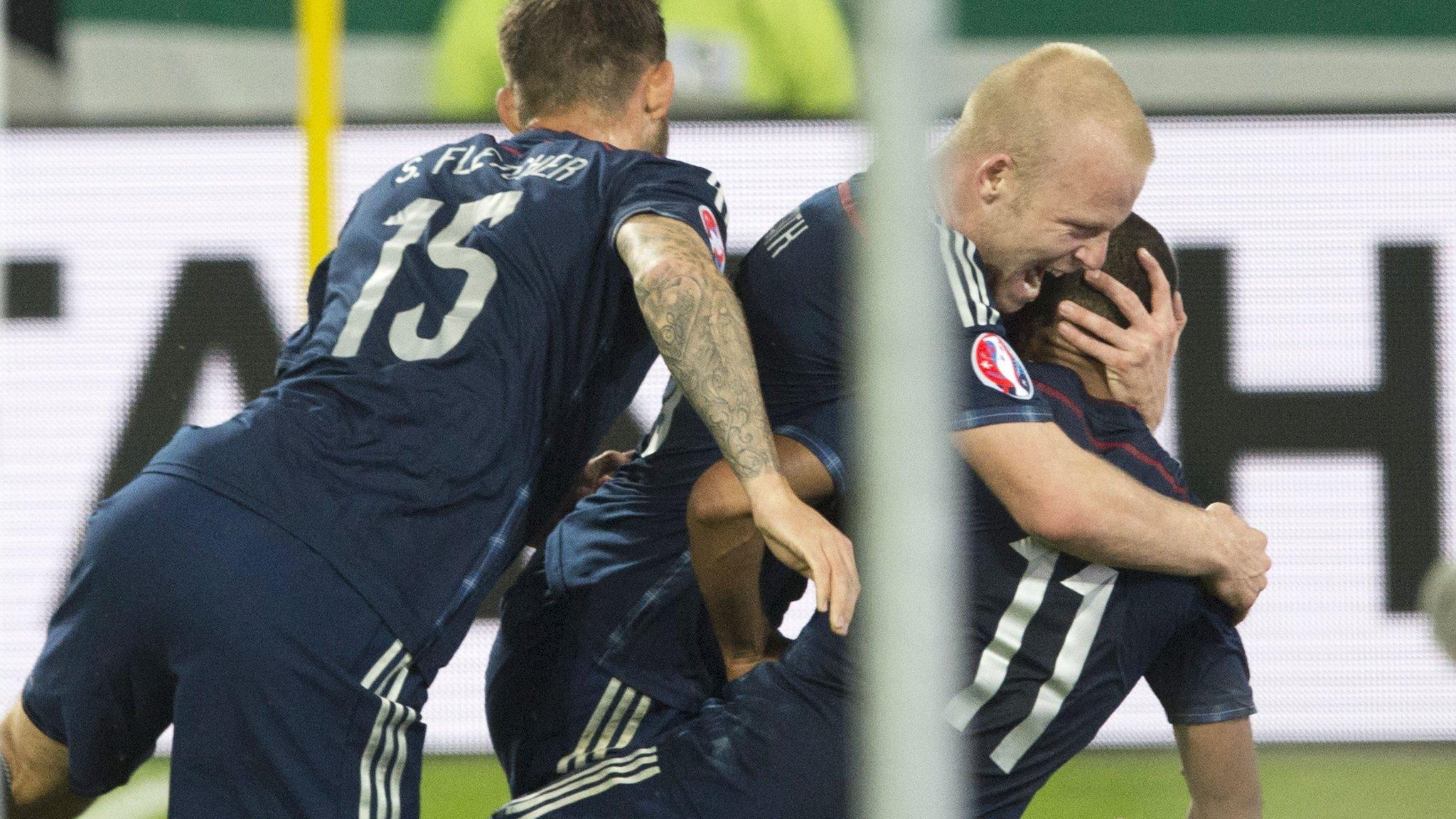 Scotland players mob Ikechi Anya after he scores an equaliser for Scotland