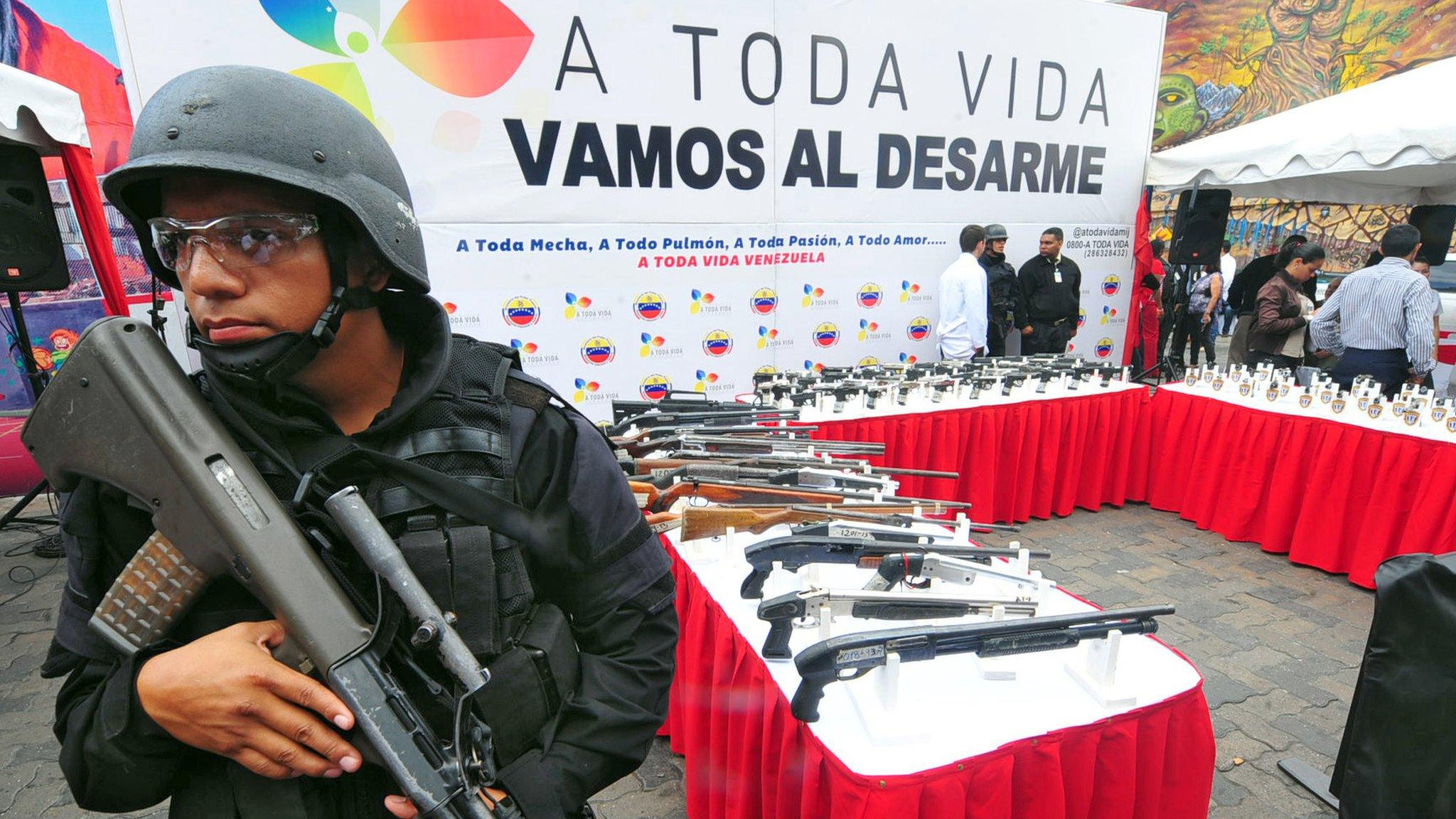 A police officer stands guard during an event to eliminate seized weapons in Caracas on 10 June, 2013