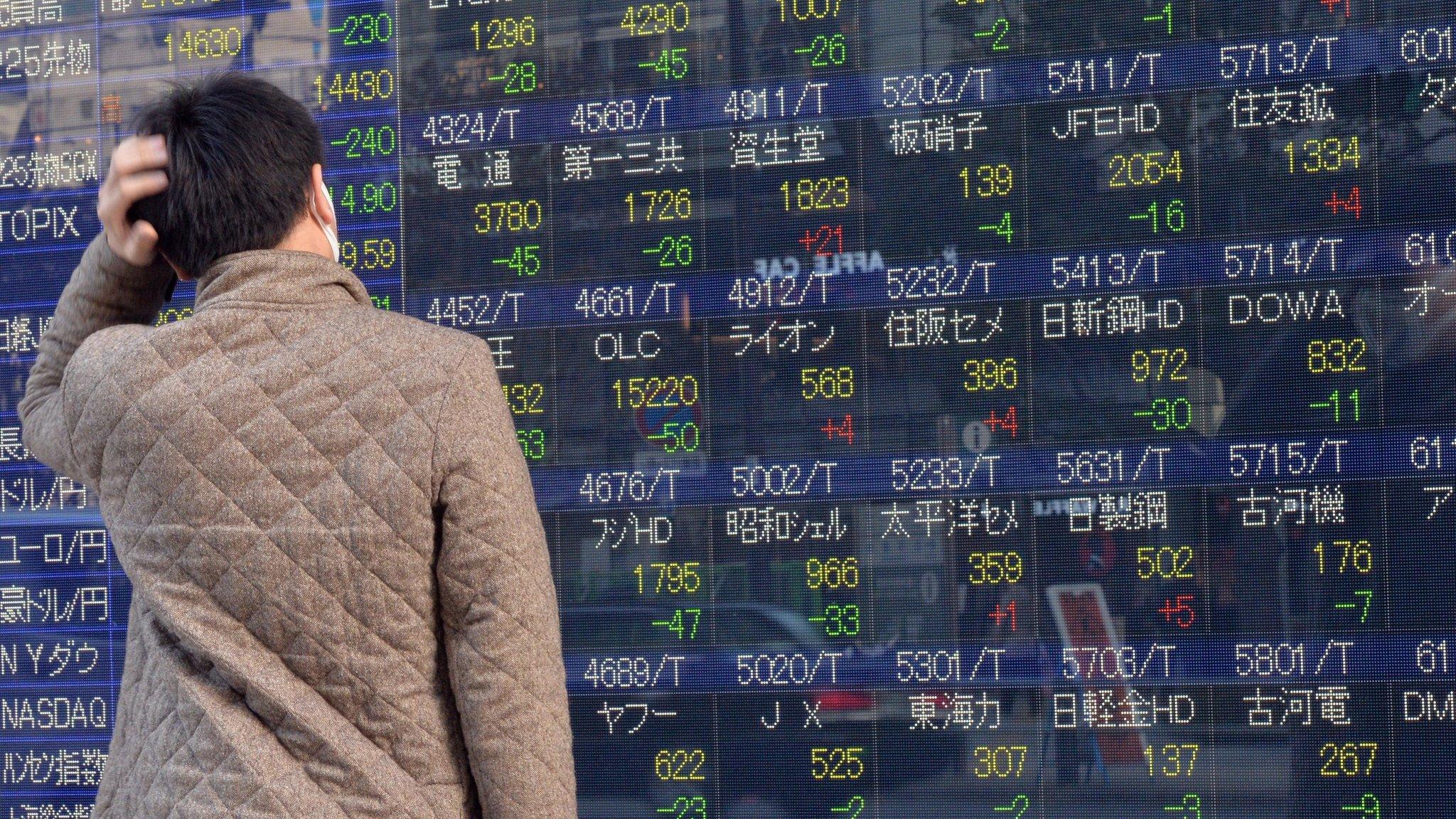 A man looking a Japan stocks board