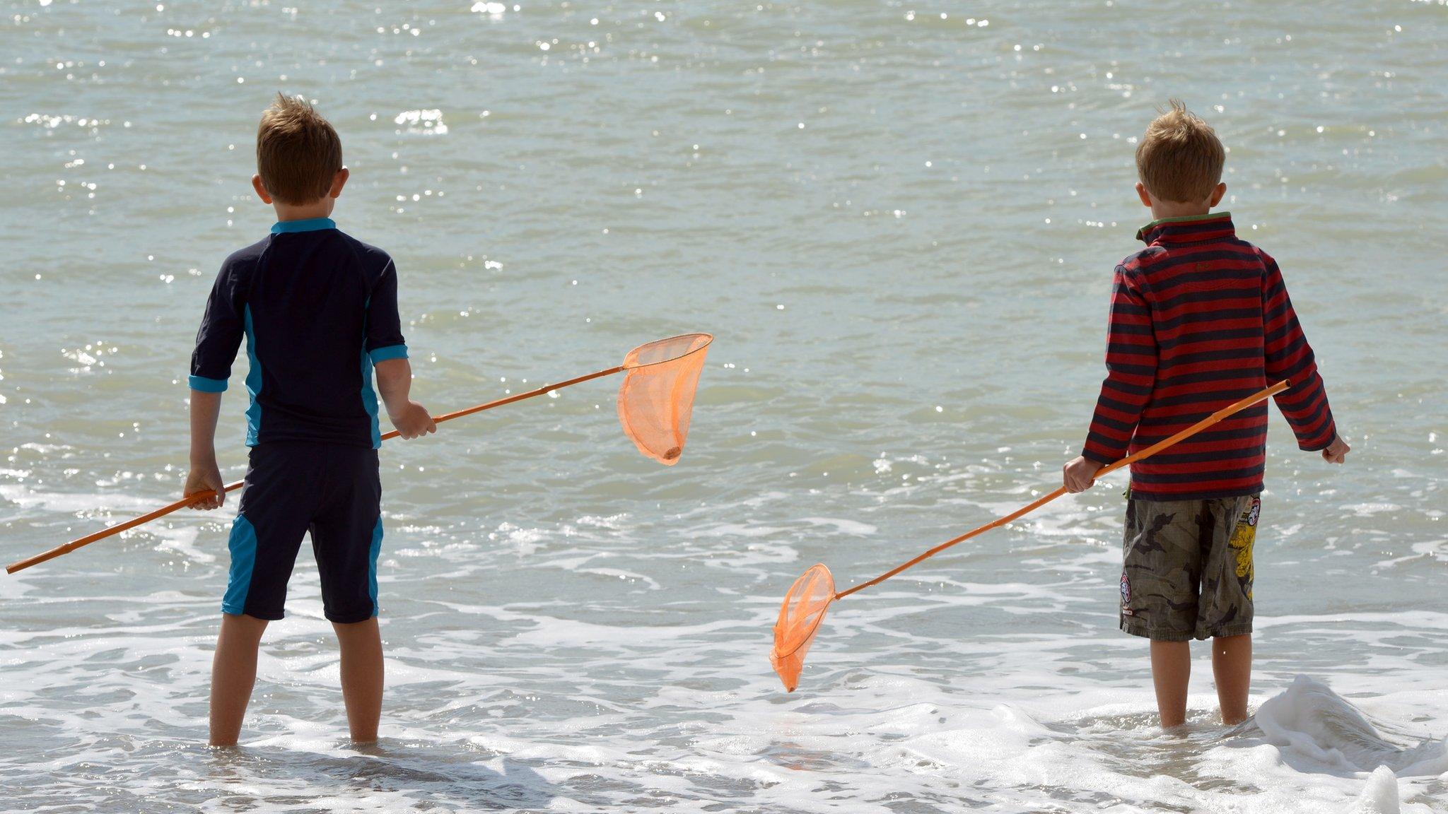 Boys standing in the sea.