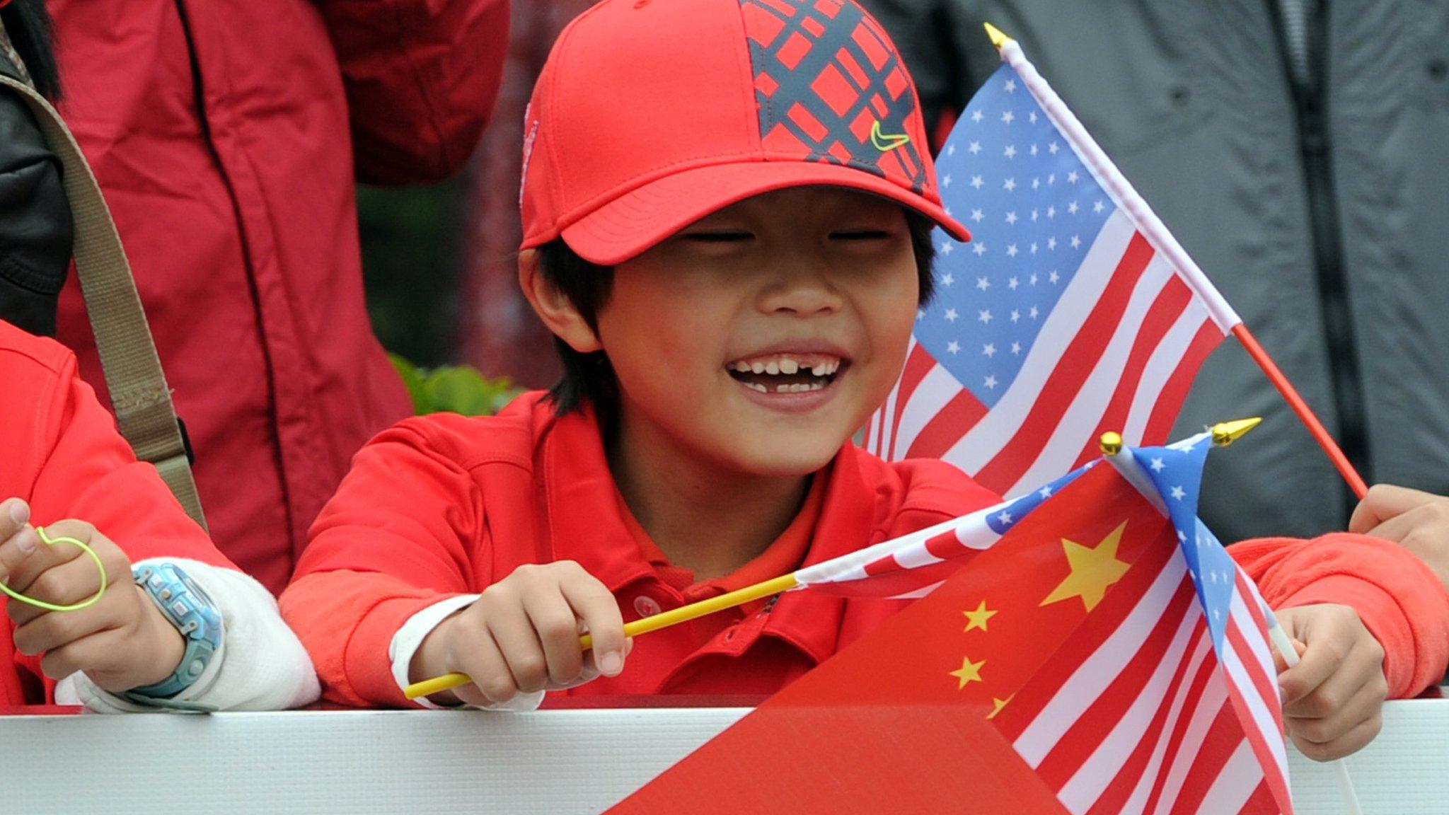 Chinese boy waving China and US flags