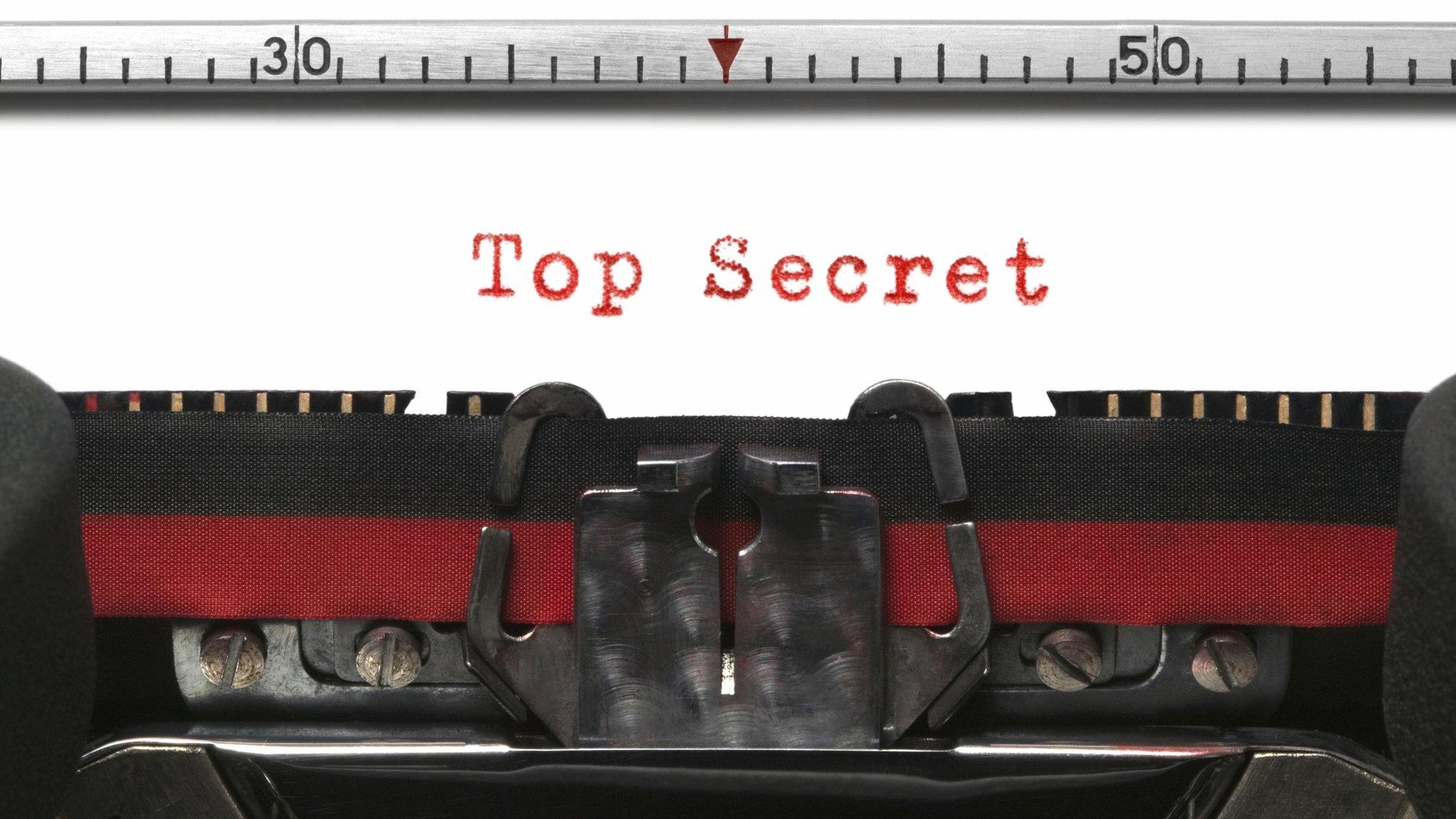 The words "Top Secret" written in red on a typewriter