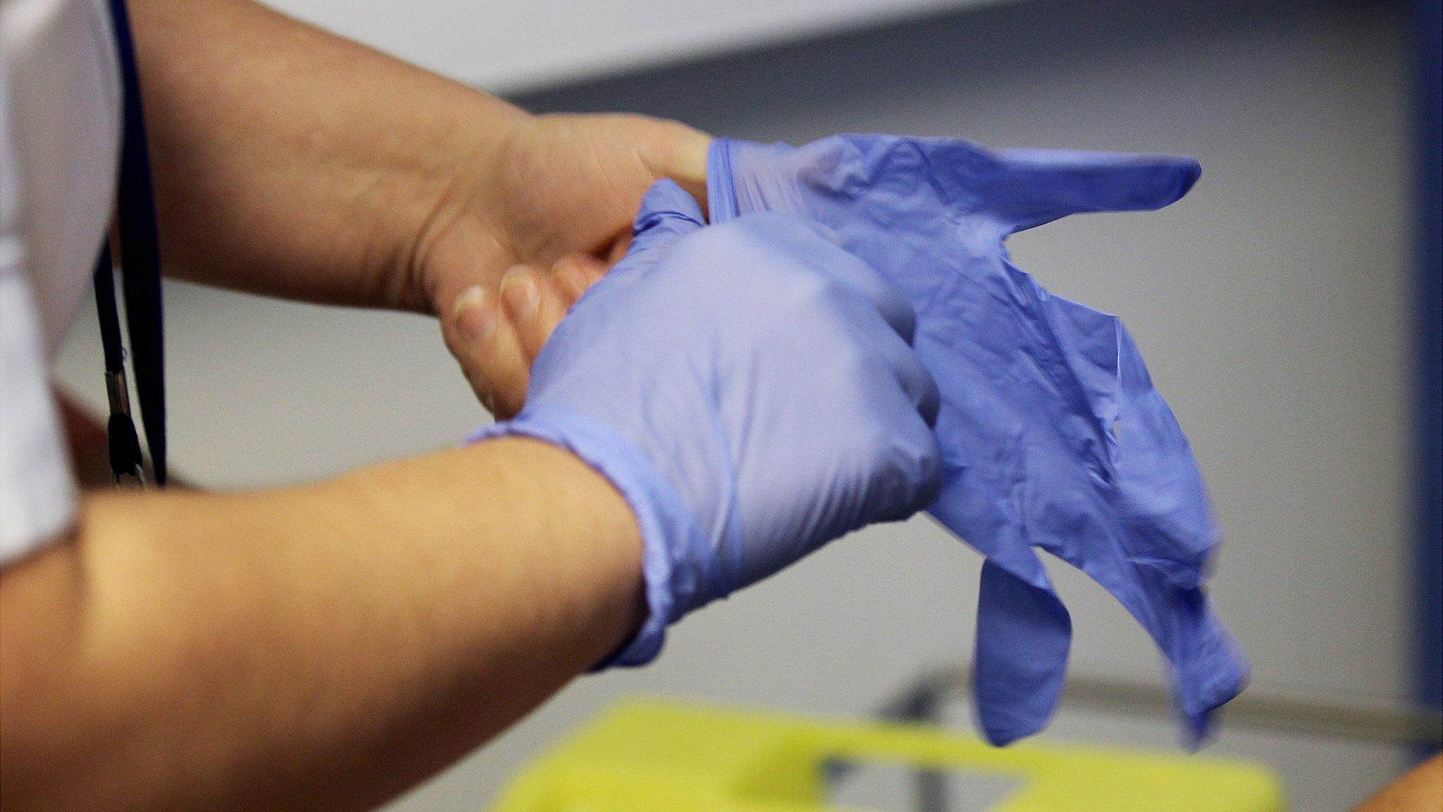 Nurse putting on gloves