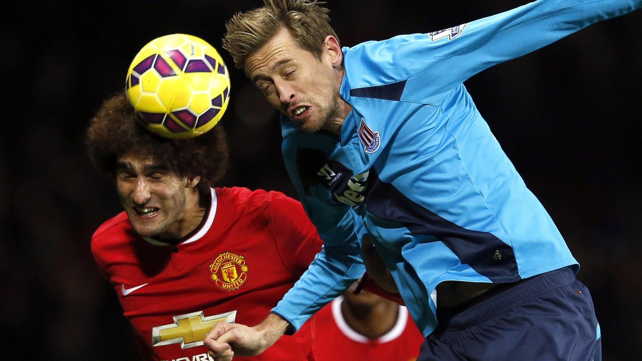 Marouane Fellaini and Peter Crouch in a headed tussle at Old Trafford