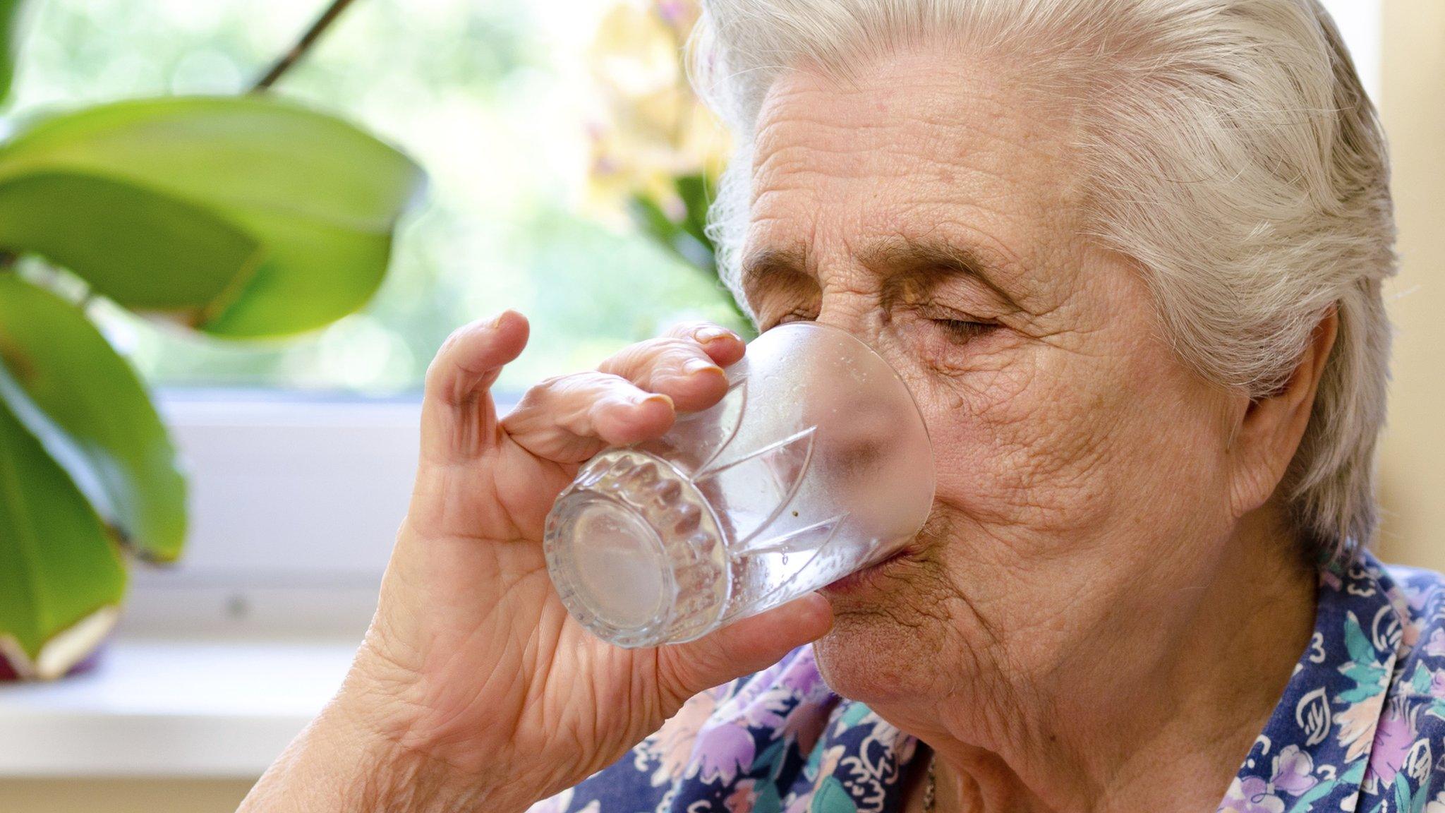 Elderly woman drinking water