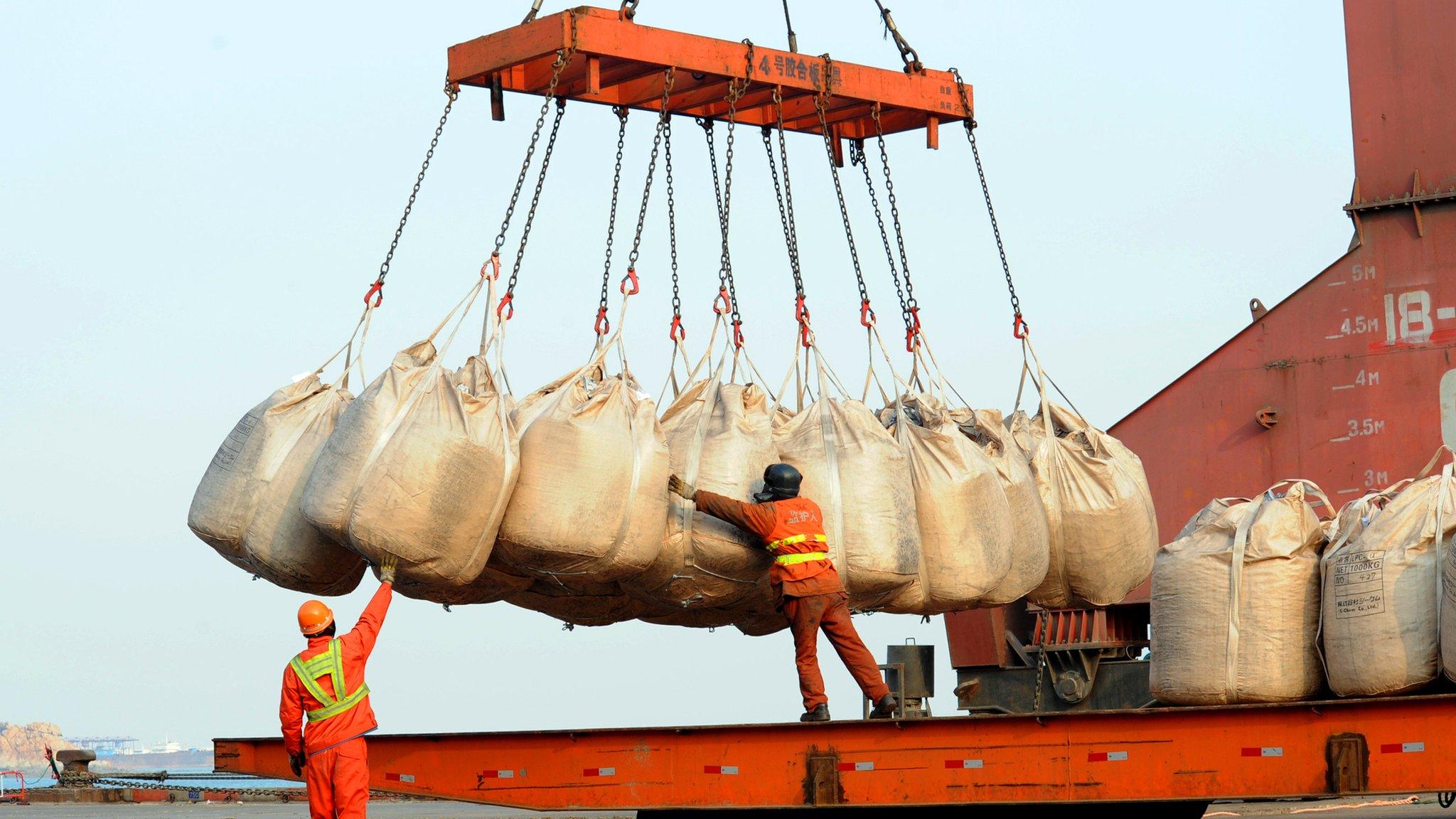 Workers unload goods from a ship at the port in Lianyungang, east China's Jiangsu province