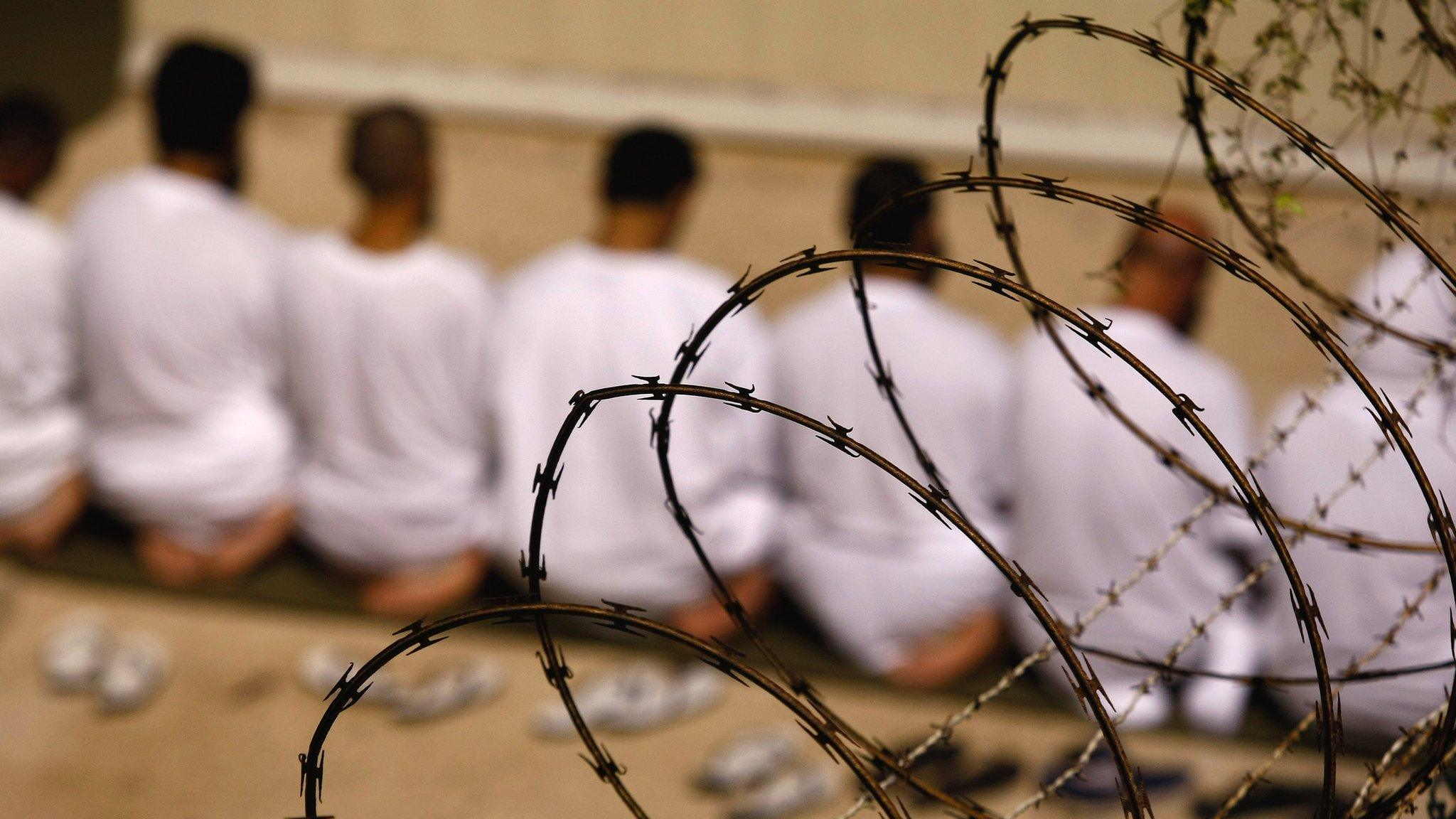 A group of detainees kneels in Guantanamo Bay, Cuba, on 28 October 2009