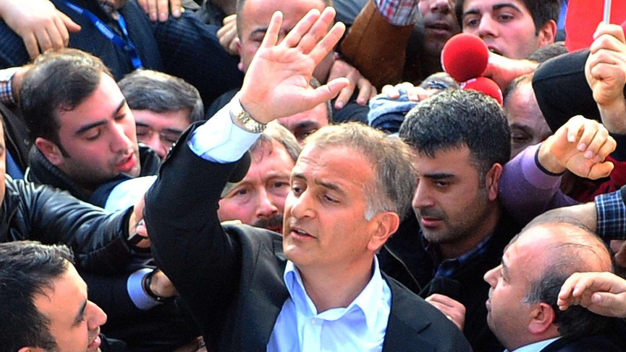 Zaman's editor-in-chief waves to staff while being arrested by counter-terror police.