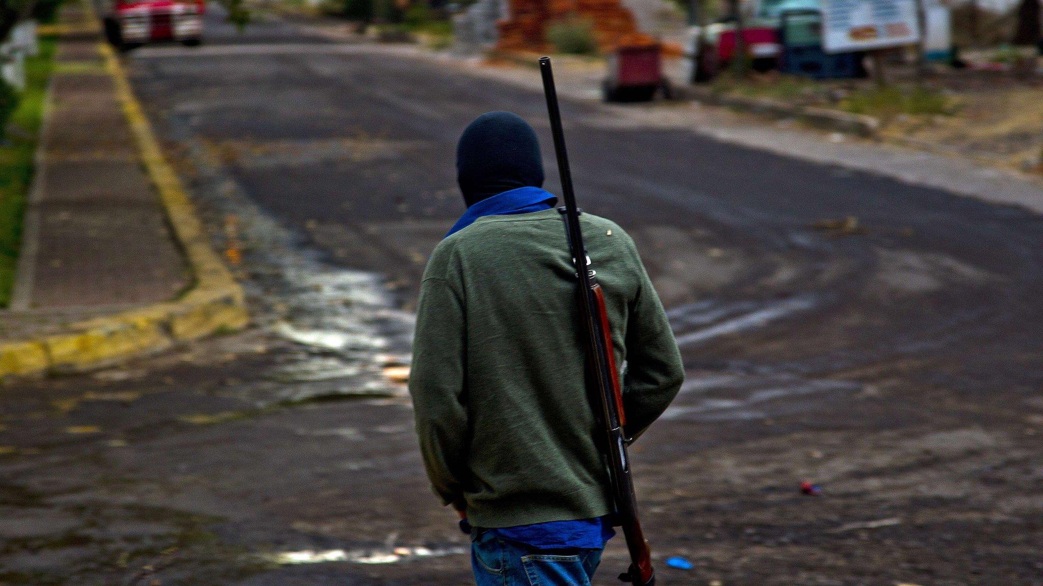 An vigilante walks along a street in Paracuaro on 16 January, 2014.