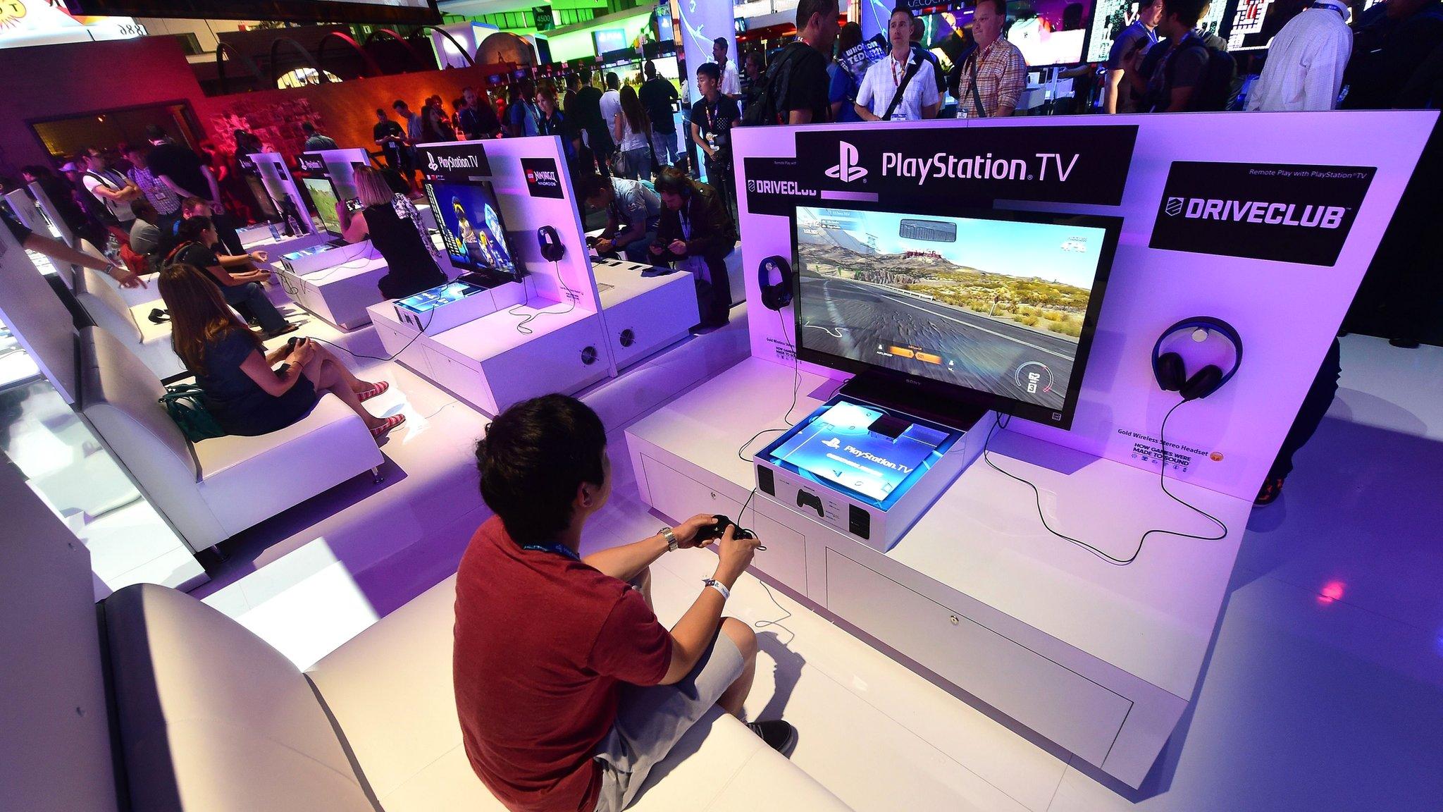 File picture shows people testing the new PlayStation TV consoles in LA (June 2014)