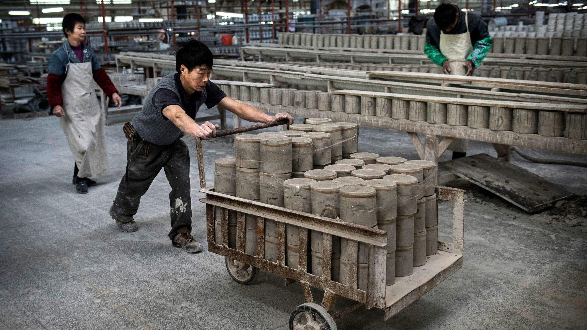 A Chinese worker pushes a cart full of clay in Dehua, Fujian Province, China.