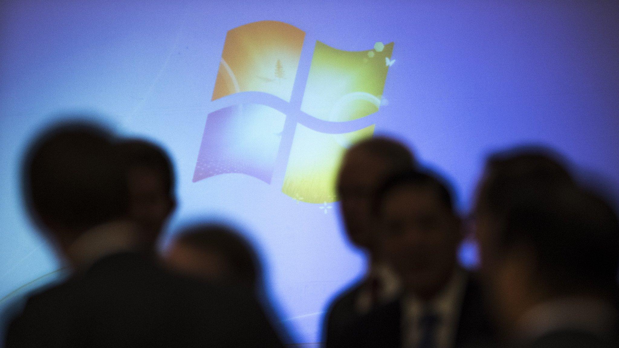 Microsoft Windows logo behind shadowed crowd