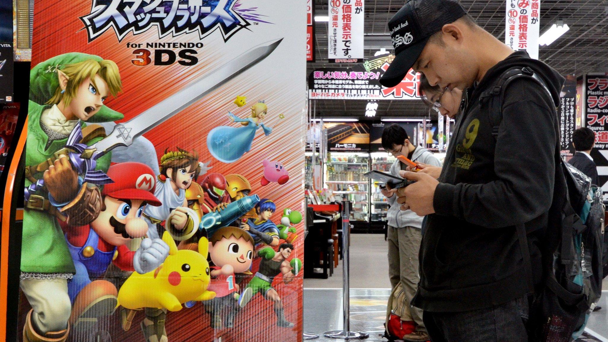 Customers play video games at an electric shop in Tokyo