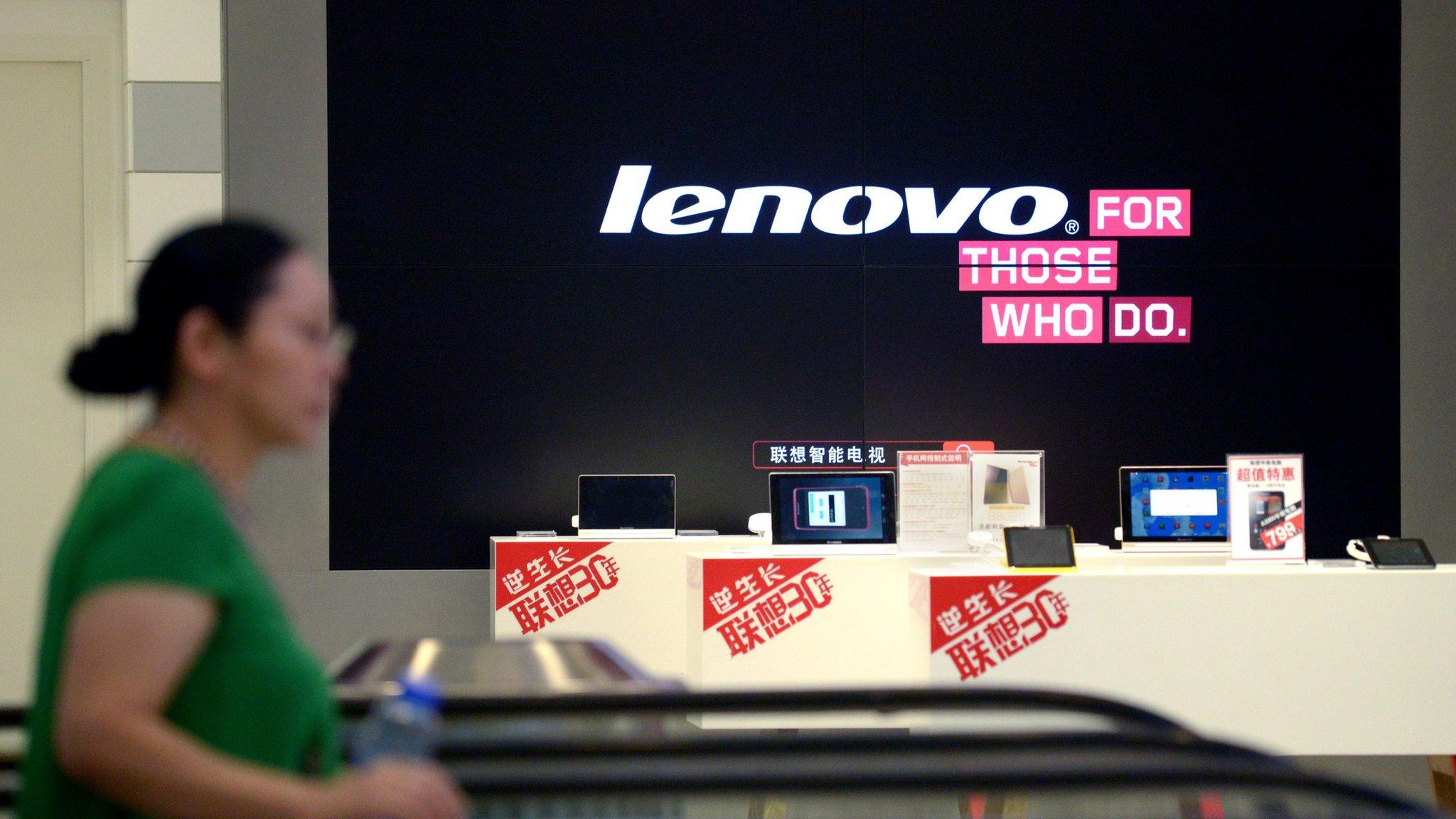 A woman walks by a Lenovo shop in China