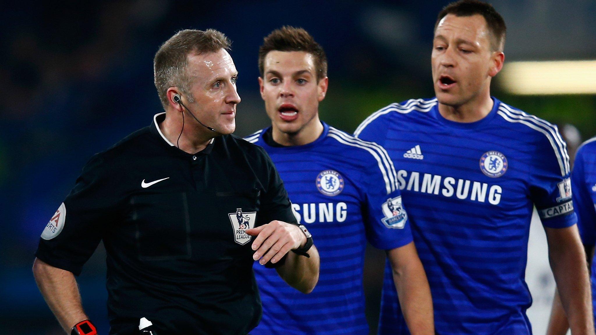 Chelsea's players surround referee Jon Moss