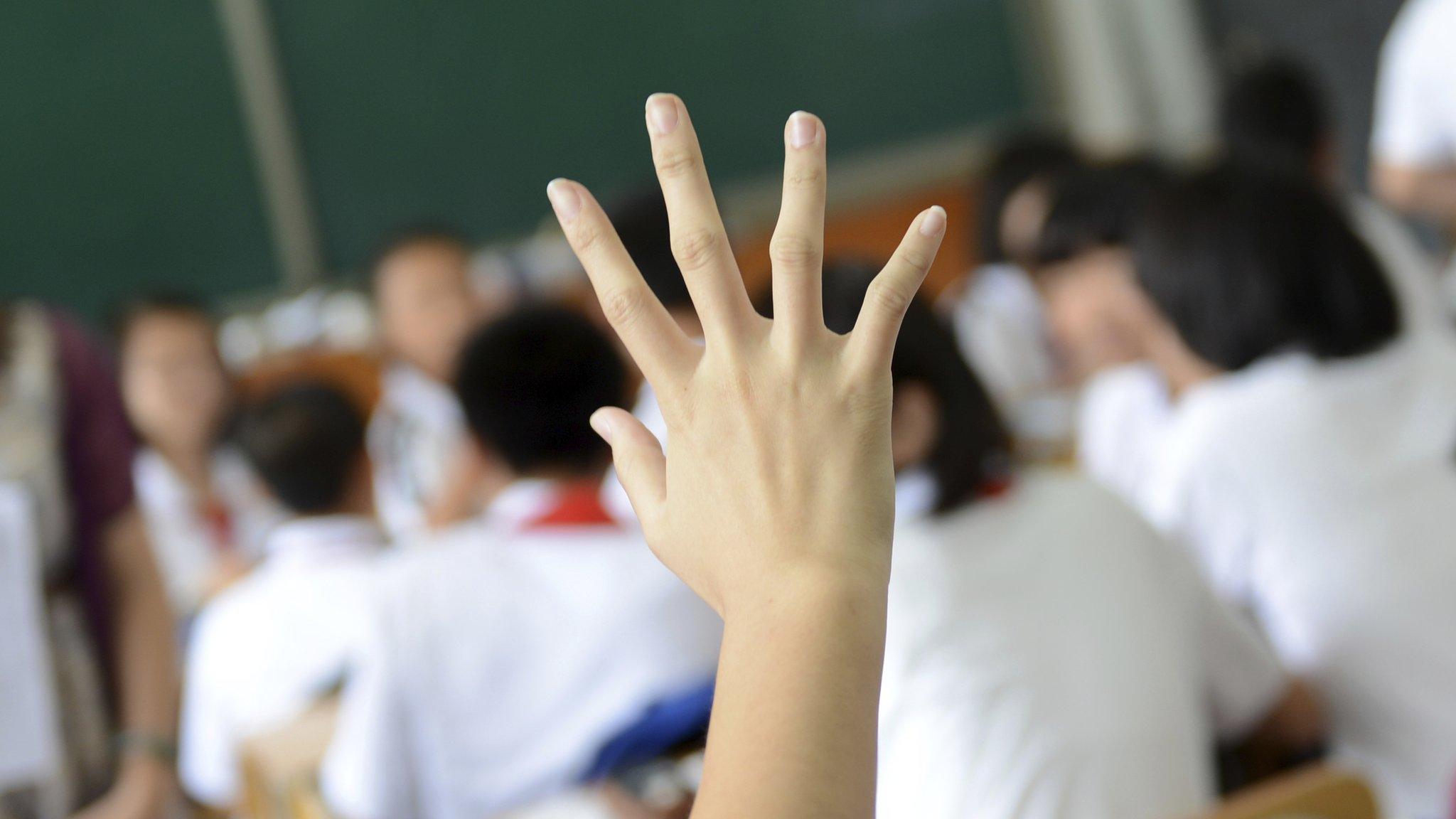 Raised hand in a classroom