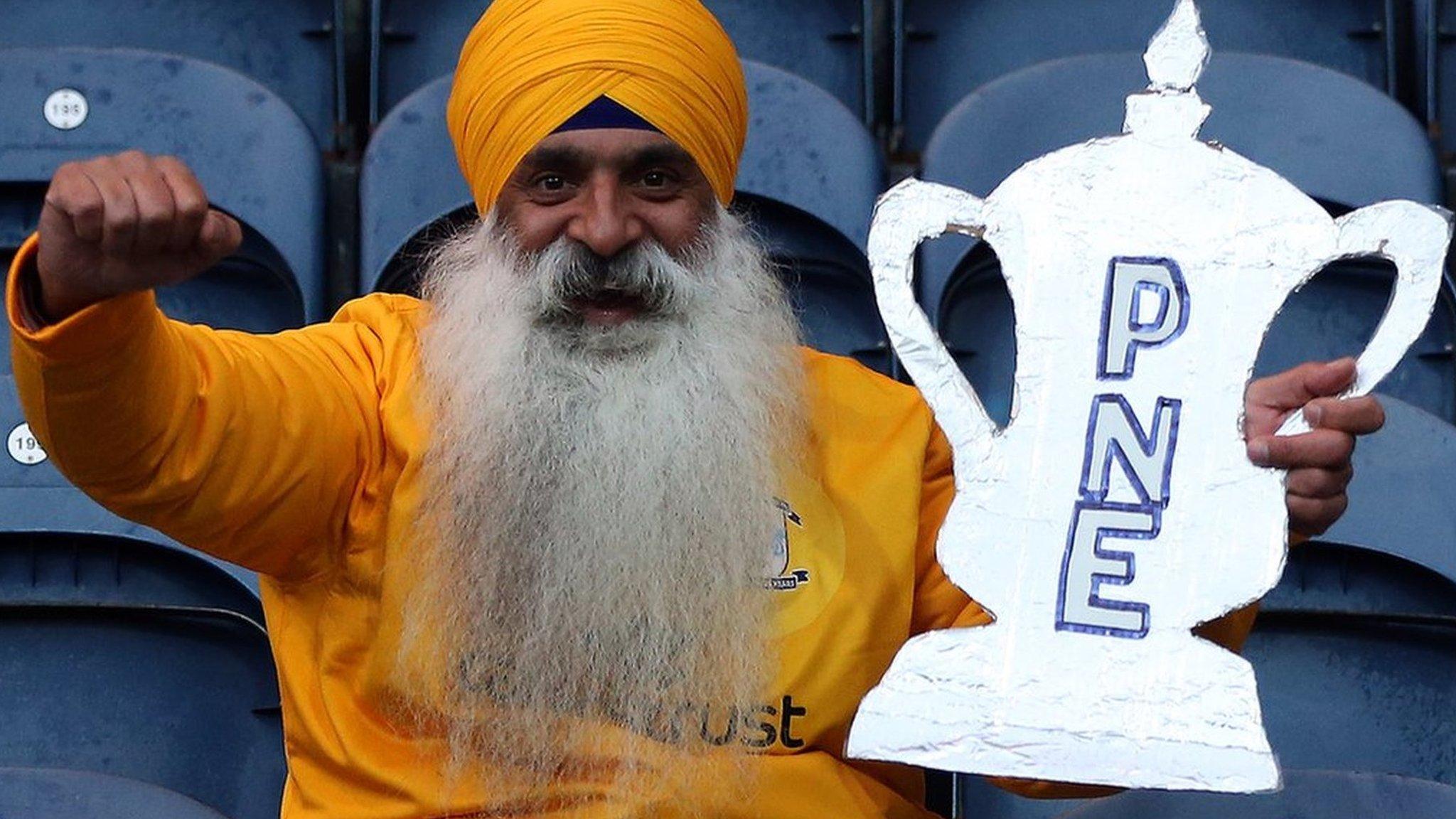 A Preston fan with a cut out of the FA Cup