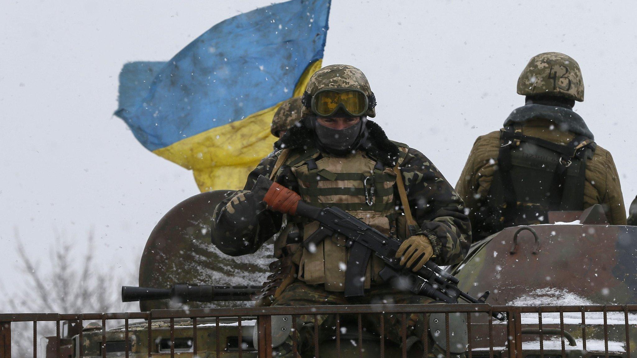 Members of the Ukrainian armed forces ride on a military vehicle near Debaltseve