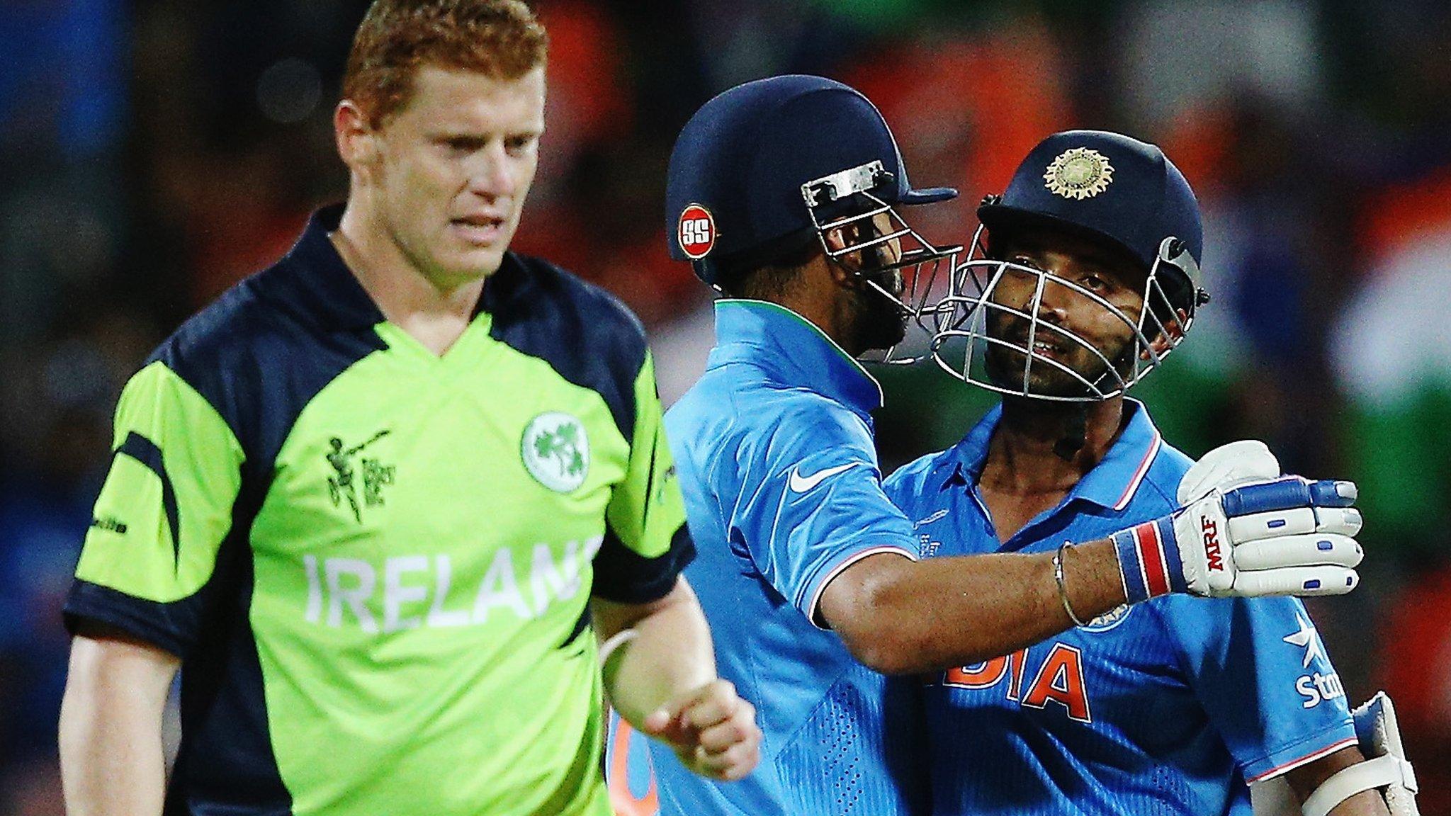 Kevin O'Brien of Ireland looks on as India's Virat Kohli and Ajinkya Rahane celebrate after winning their World Cup match