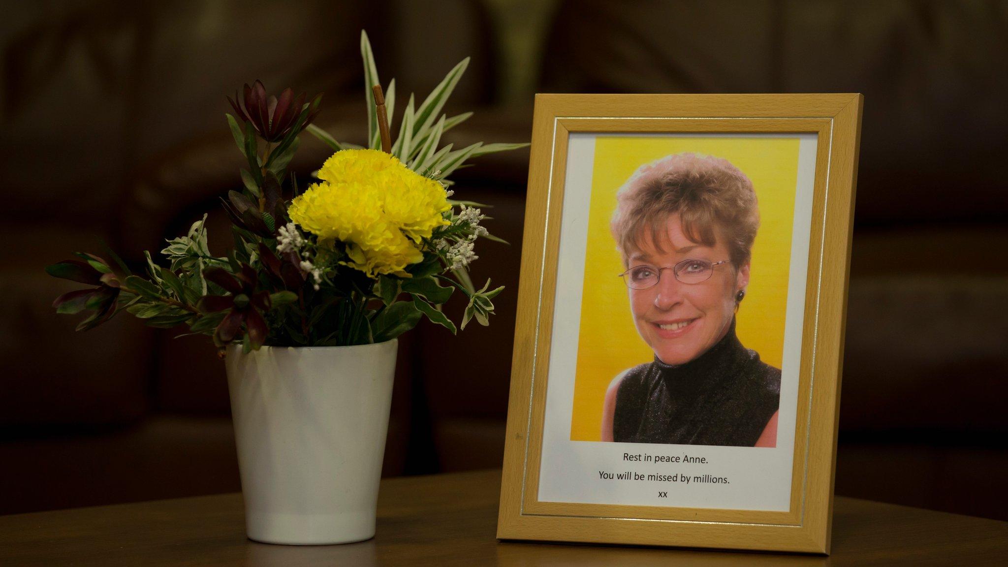 Framed photograph of Anne Kirkbride next to flowers