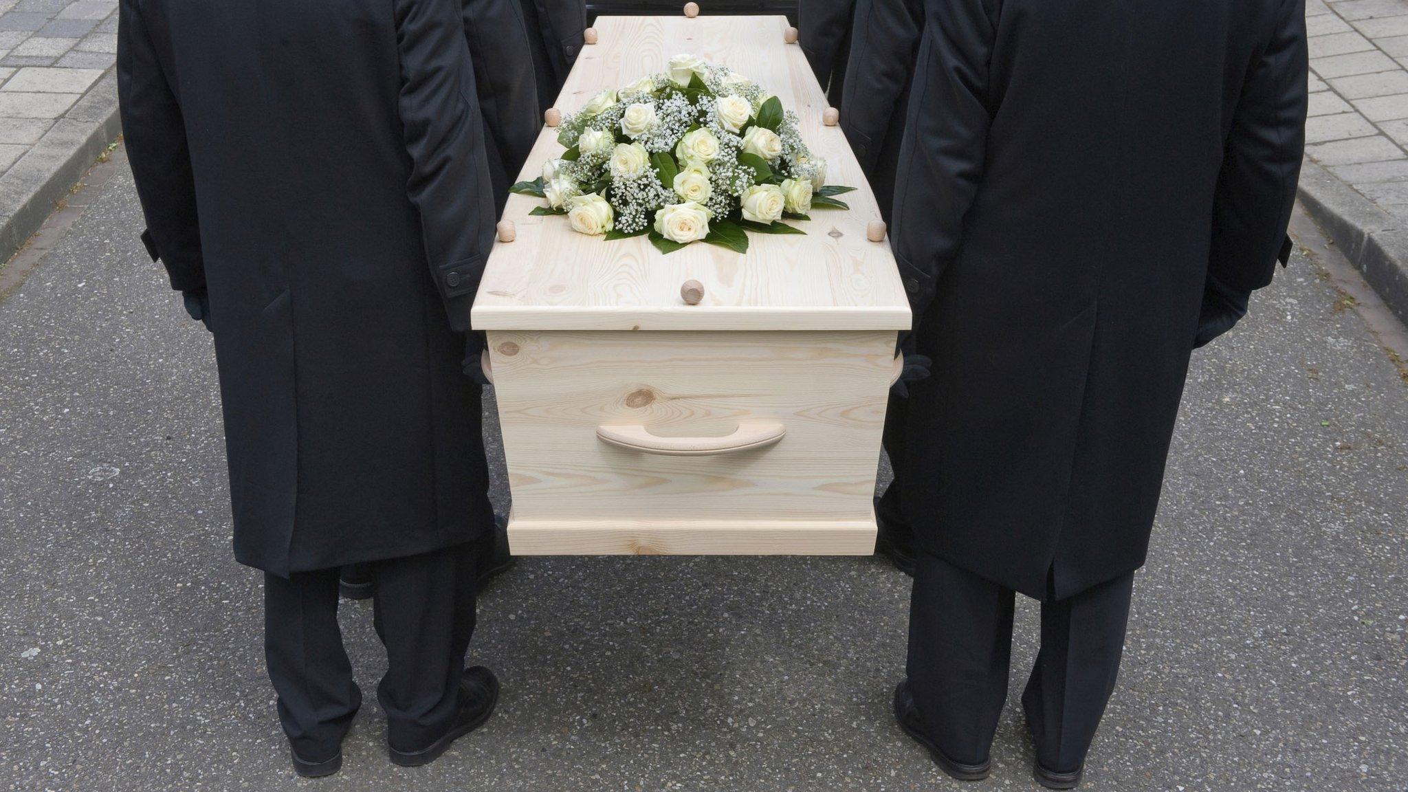 People holding a coffin