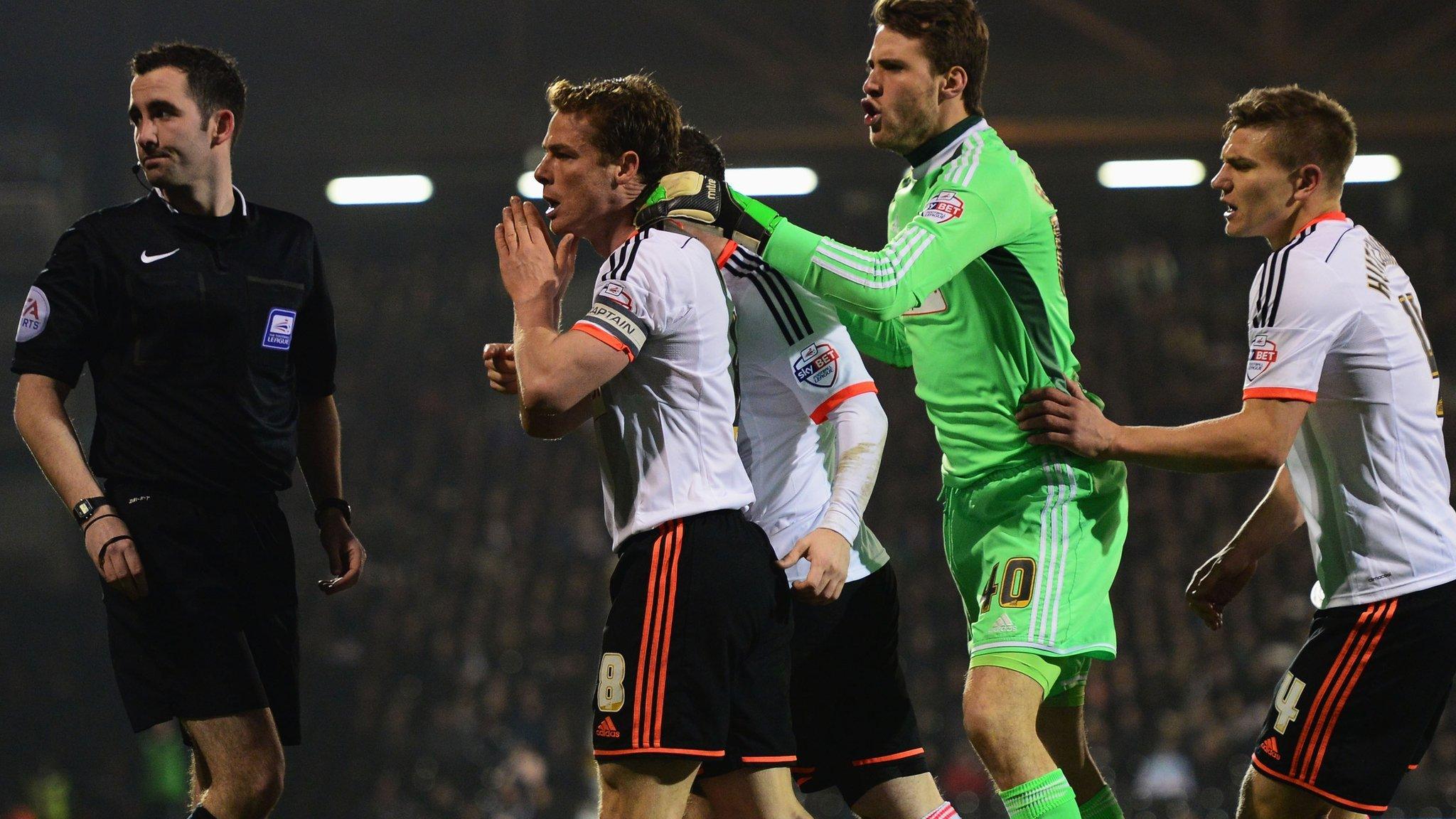 Fulham players argue with the referee