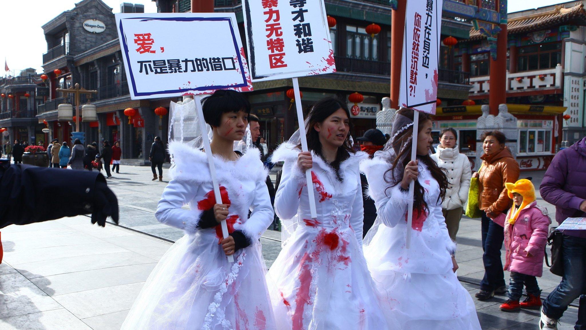 Li Tingting in the middle and two others wear paint-spattered wedding dresses