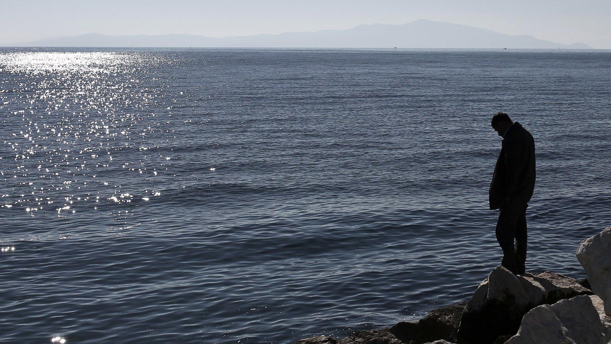 Man stands on sea shore