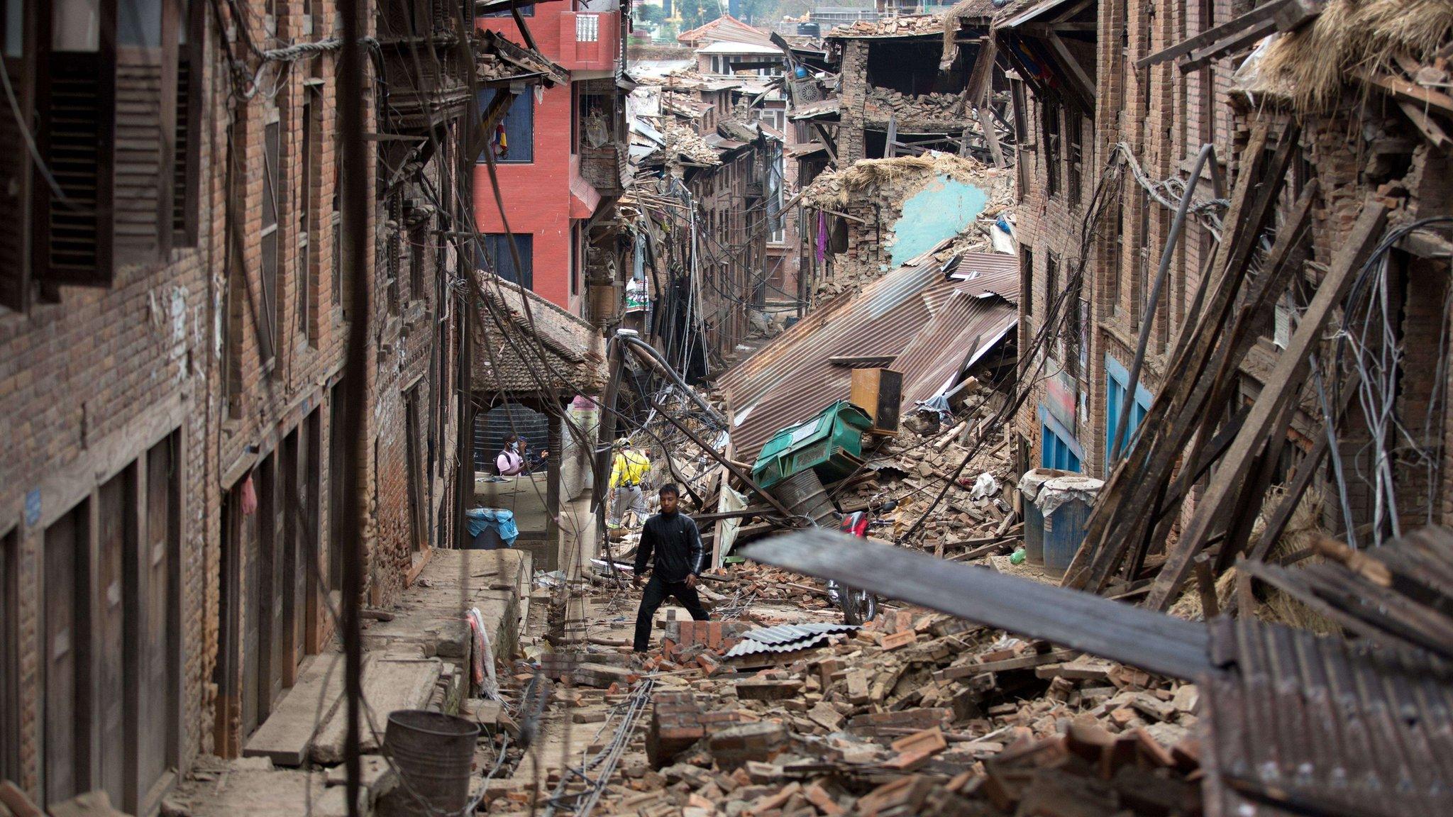 Man walks through rubble of houses damaged by the earthquake in Bhaktapur near Kathmandu on 28 April 2015.