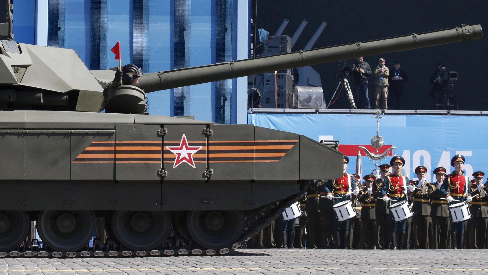 A Russian tank driver holds a red flag in Moscow. Photo: 7 May 2015