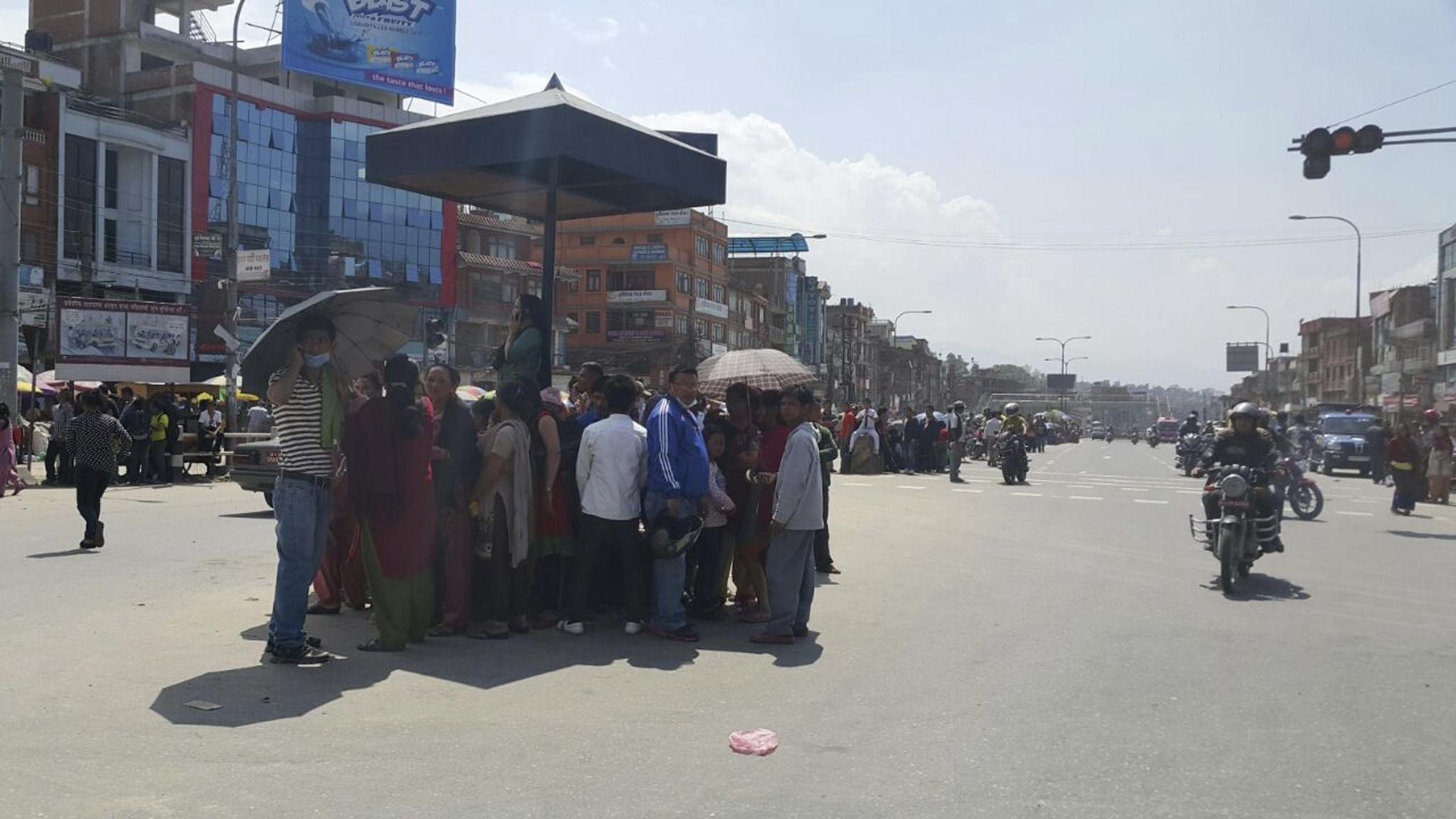 People gather in the middle of a road during the earthquake in Bhaktapur, Nepal