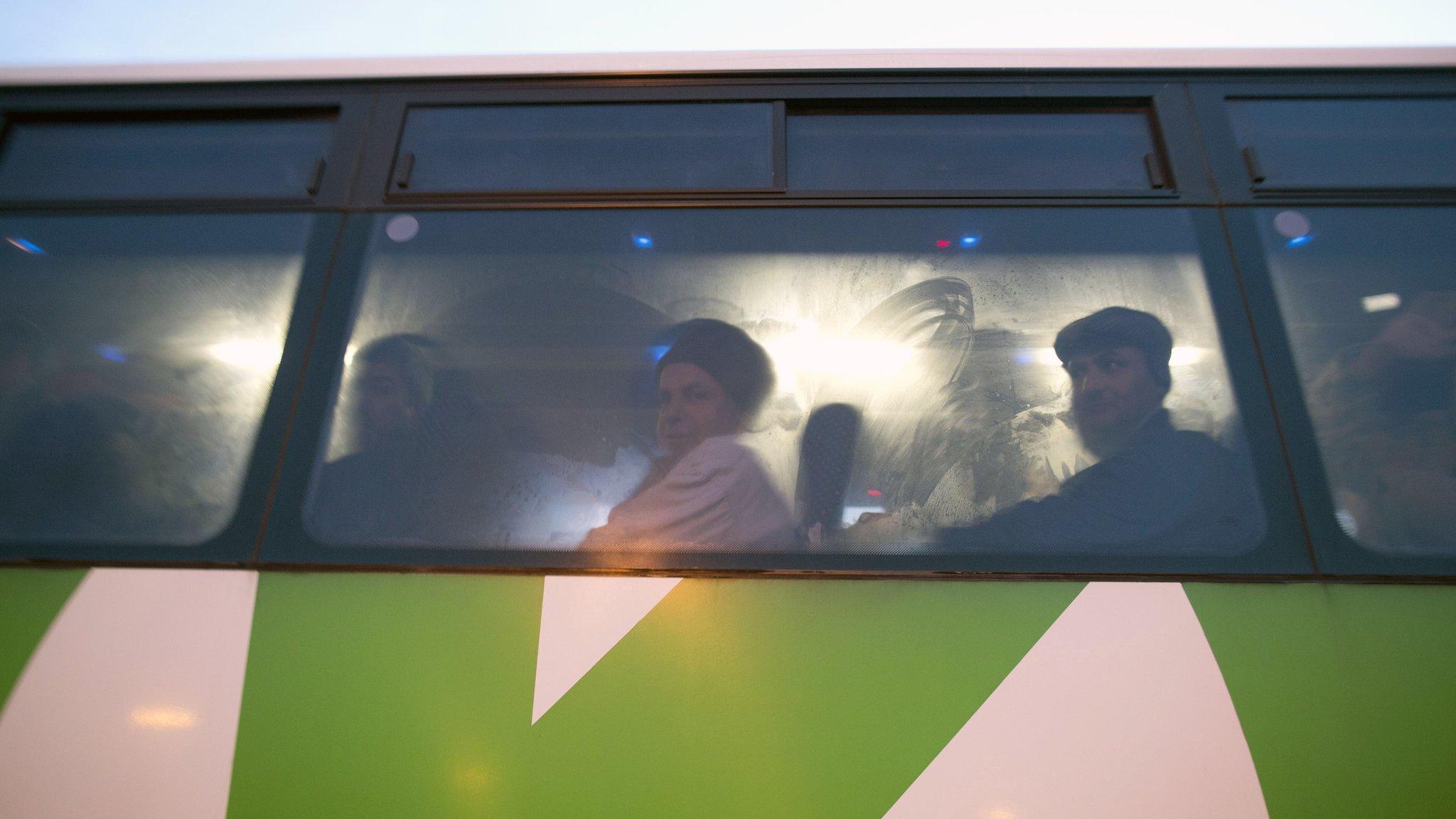 Palestinians sit in a bus as a new line is made available by Israel to take Palestinian labourers from the Israeli army crossing Eyal, near the West Bank town of Qalqilya, into the Israeli city Tel Aviv, 4 March 2013