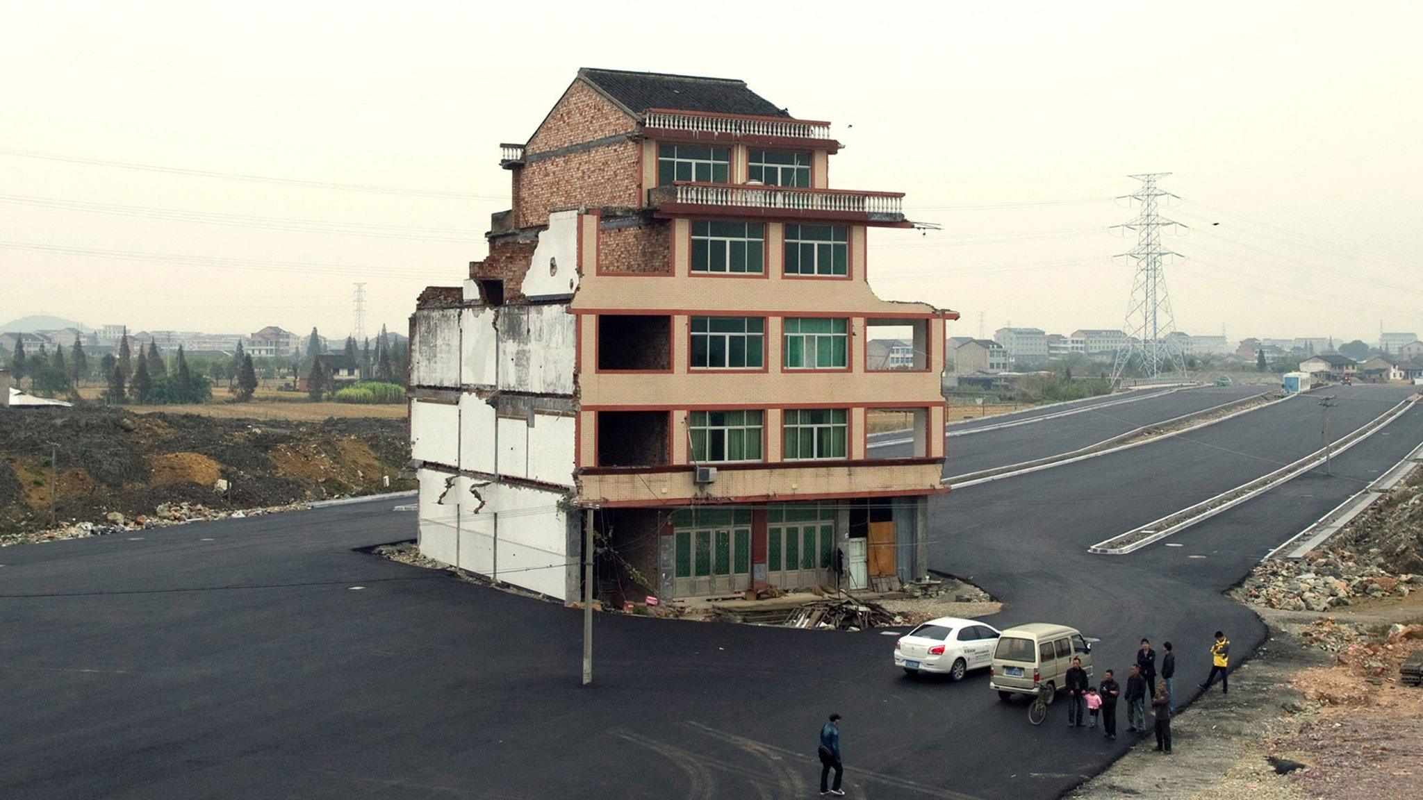 A five-storey apartment building in the middle of a newly-built road in Wenling, in eastern China's Zhejiang province