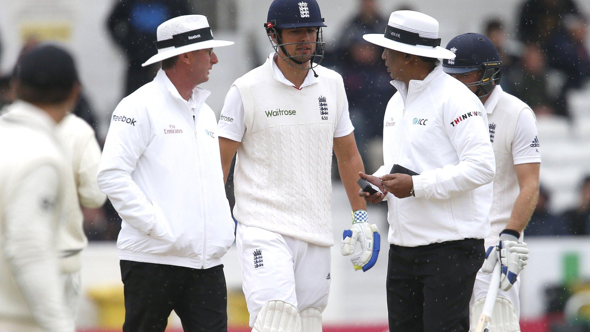 Alastair Cook talks to the umpires