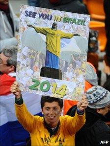 Supporter holds sign reading "See you in Brazil in 2014"