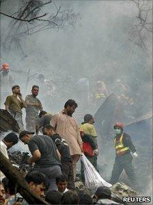 Rescue workers search the site of the crash of an Airblue passenger plane on the outskirts of Islamabad