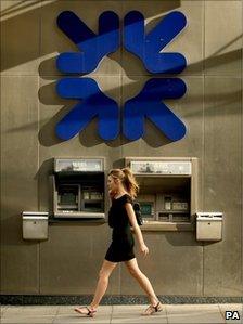 Woman walks past an RBS branch