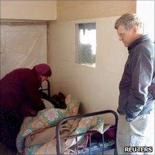 Tom Little watches as an unidentified doctor examine a patient in an Afghan clinic