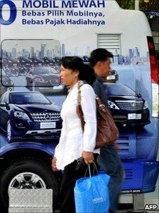 Pedestrians walk past a state-own-bank advertisement in Jakarta