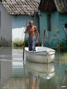 Man stands in boat on flooded street in Villahermosa in Tabasco on 7 September